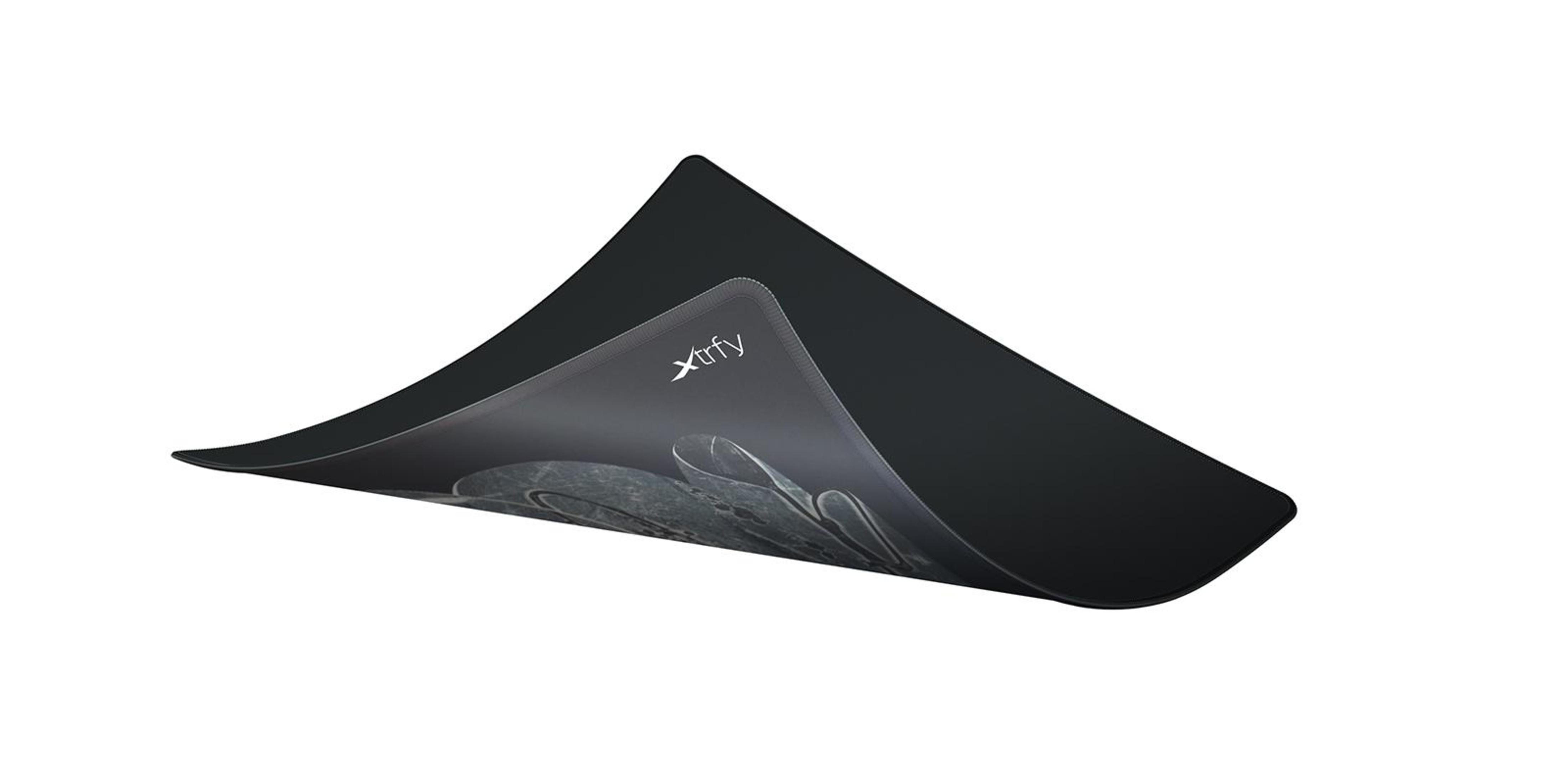 Un mousepad nero su sfondo bianco. Lo strato superiore è sollevato, rivelando un design grigio e il logo Xtrfy.