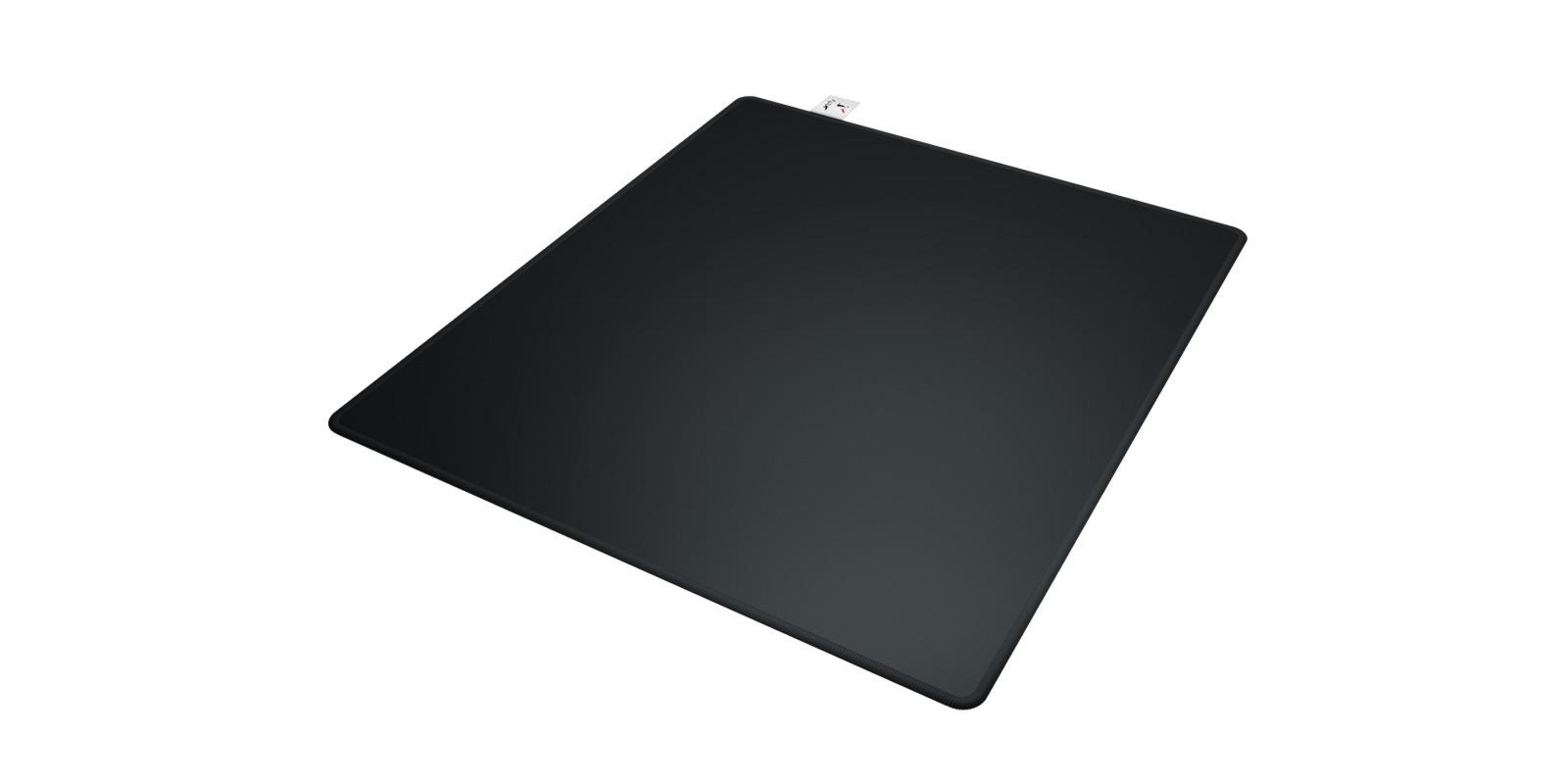 Un tapis de souris rectangulaire noir sur fond blanc. Une petite étiquette est fixée sur le bord supérieur.