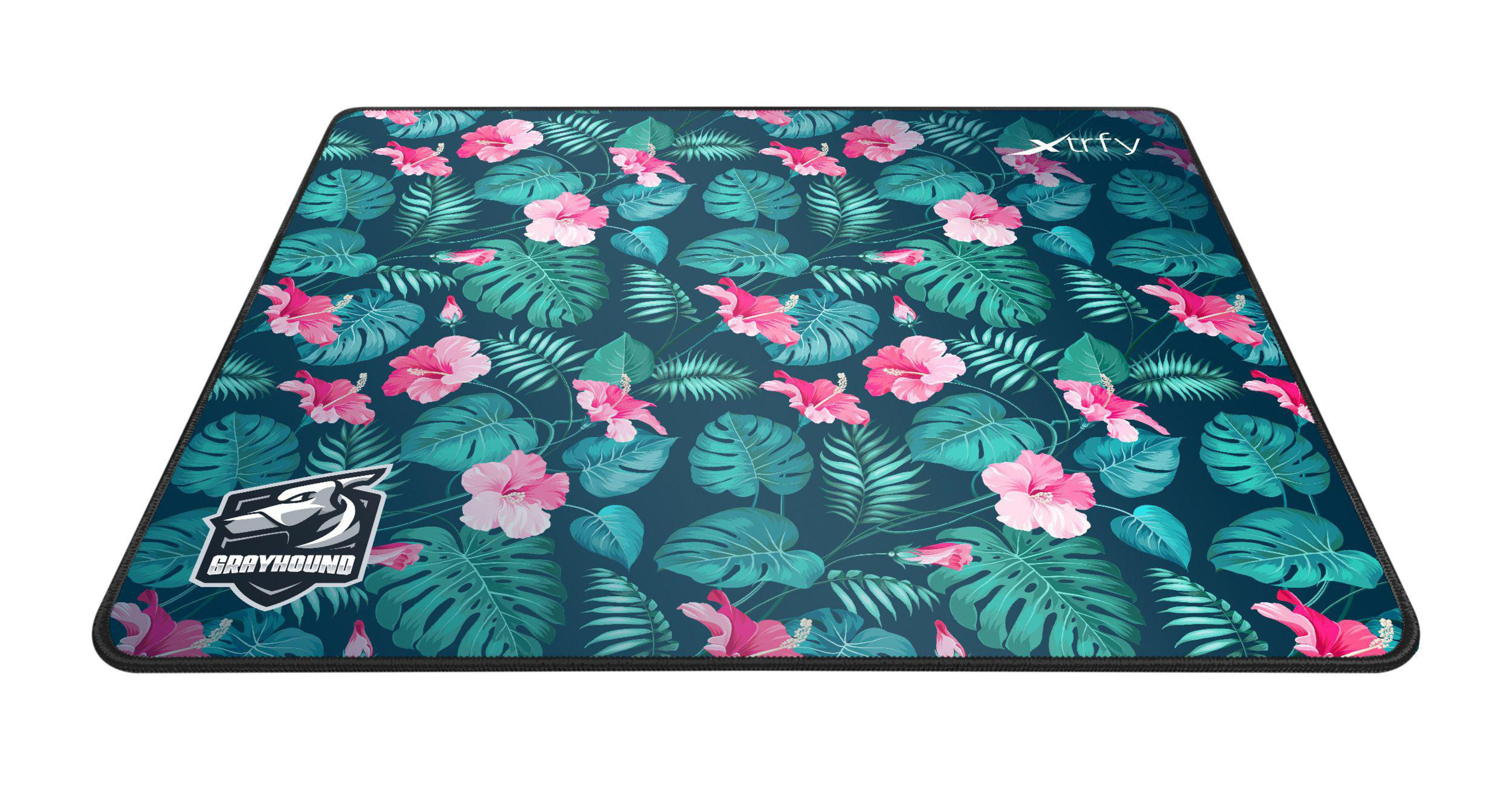Tapis de souris avec un motif floral mettant en vedette des fleurs d'hibiscus roses et des feuilles tropicales vertes sur fond bleu foncé.
