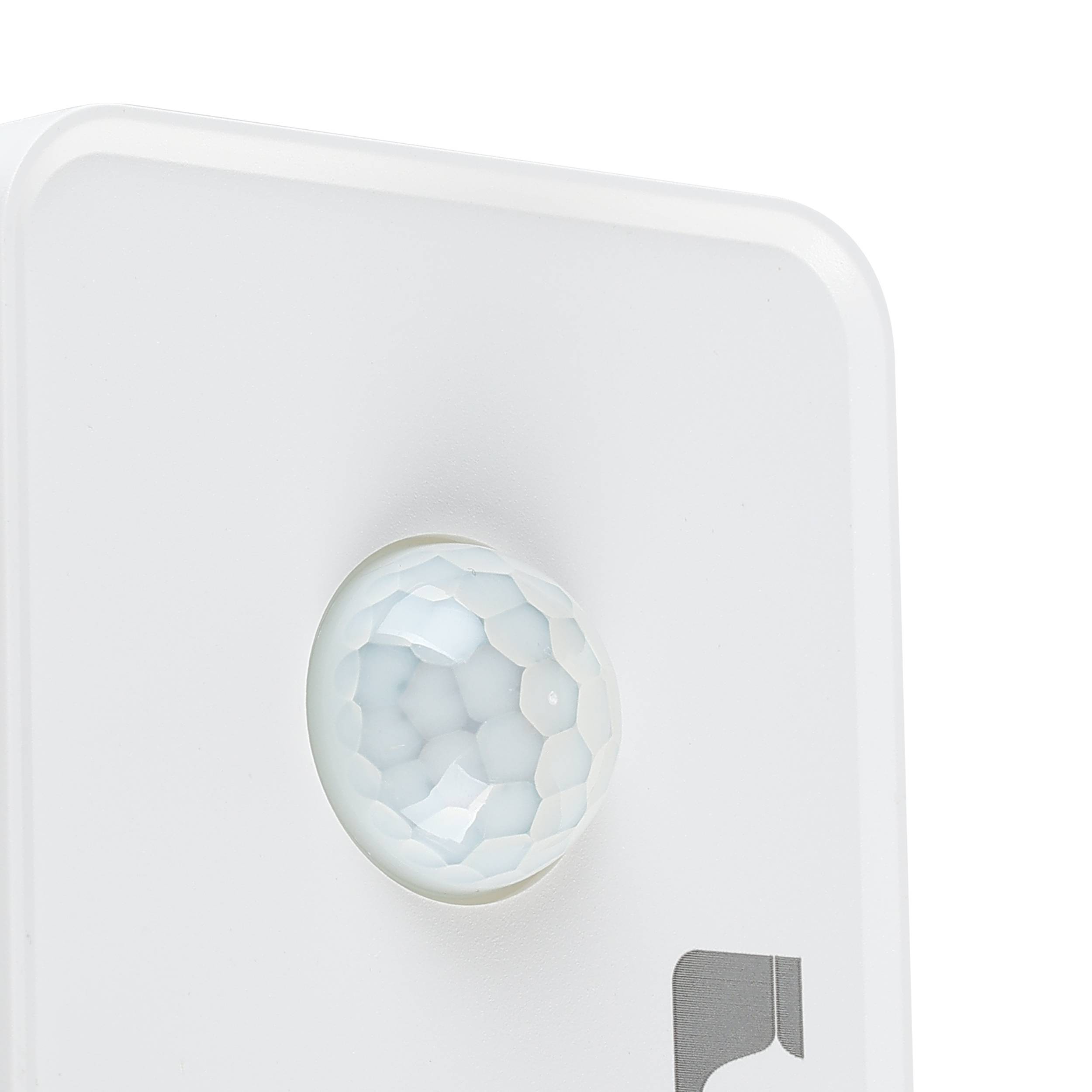 Un sensore di movimento bianco con una lente traslucida e sfaccettata. Il dispositivo su sfondo bianco, primo piano.