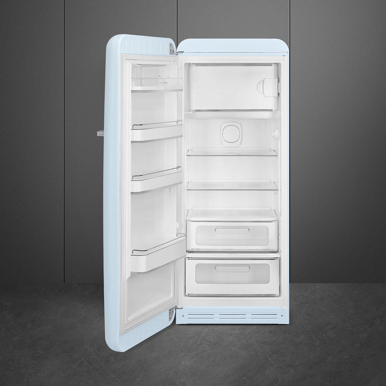 Un frigorifero retrò azzurro chiaro con la porta aperta. All'interno ci sono ripiani e cassetti. Lo sfondo è un muro grigio scuro.