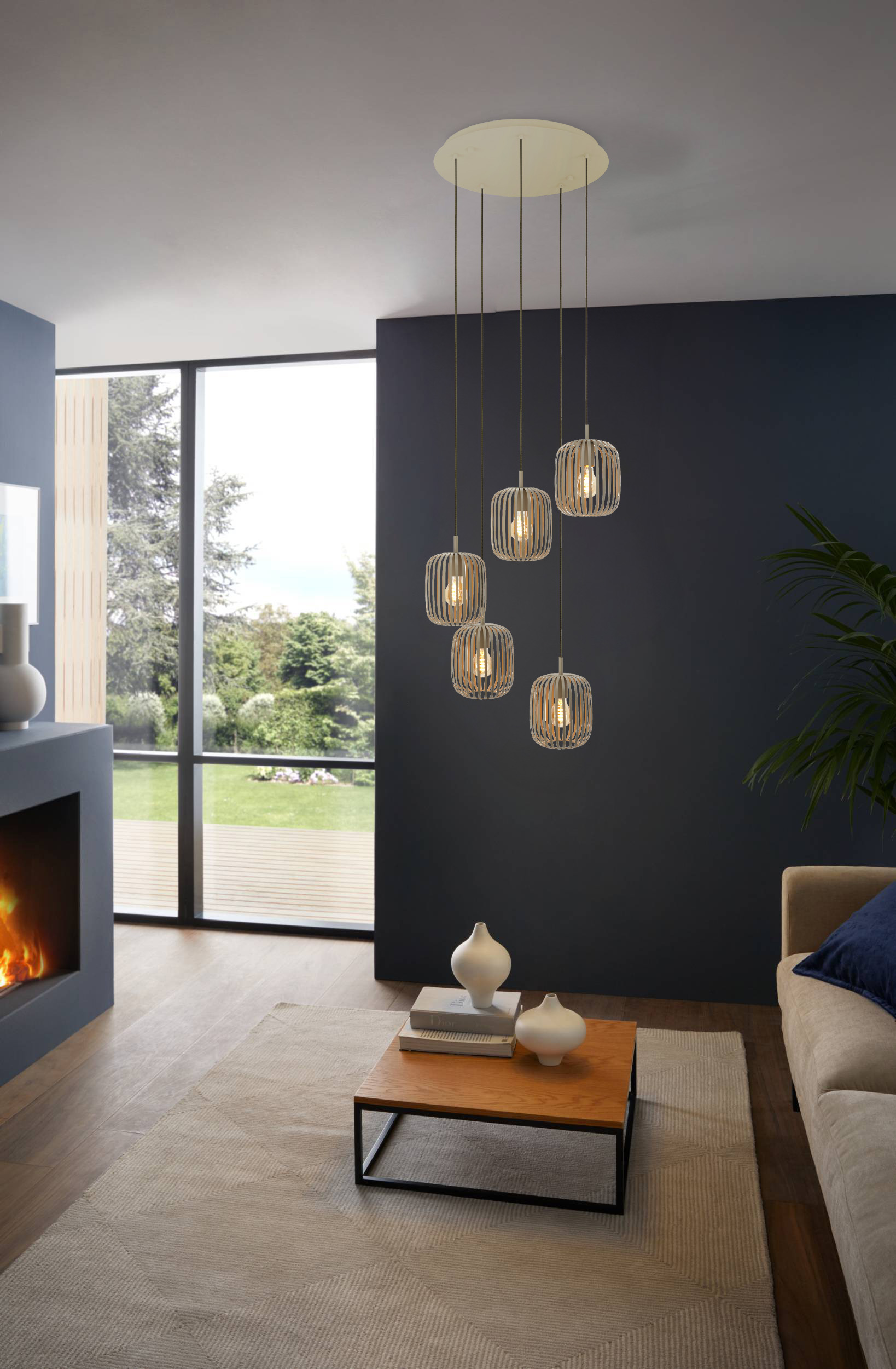 Een moderne woonkamer met hanglampen, een open haard, een bank en een groot raam met uitzicht op bomen.