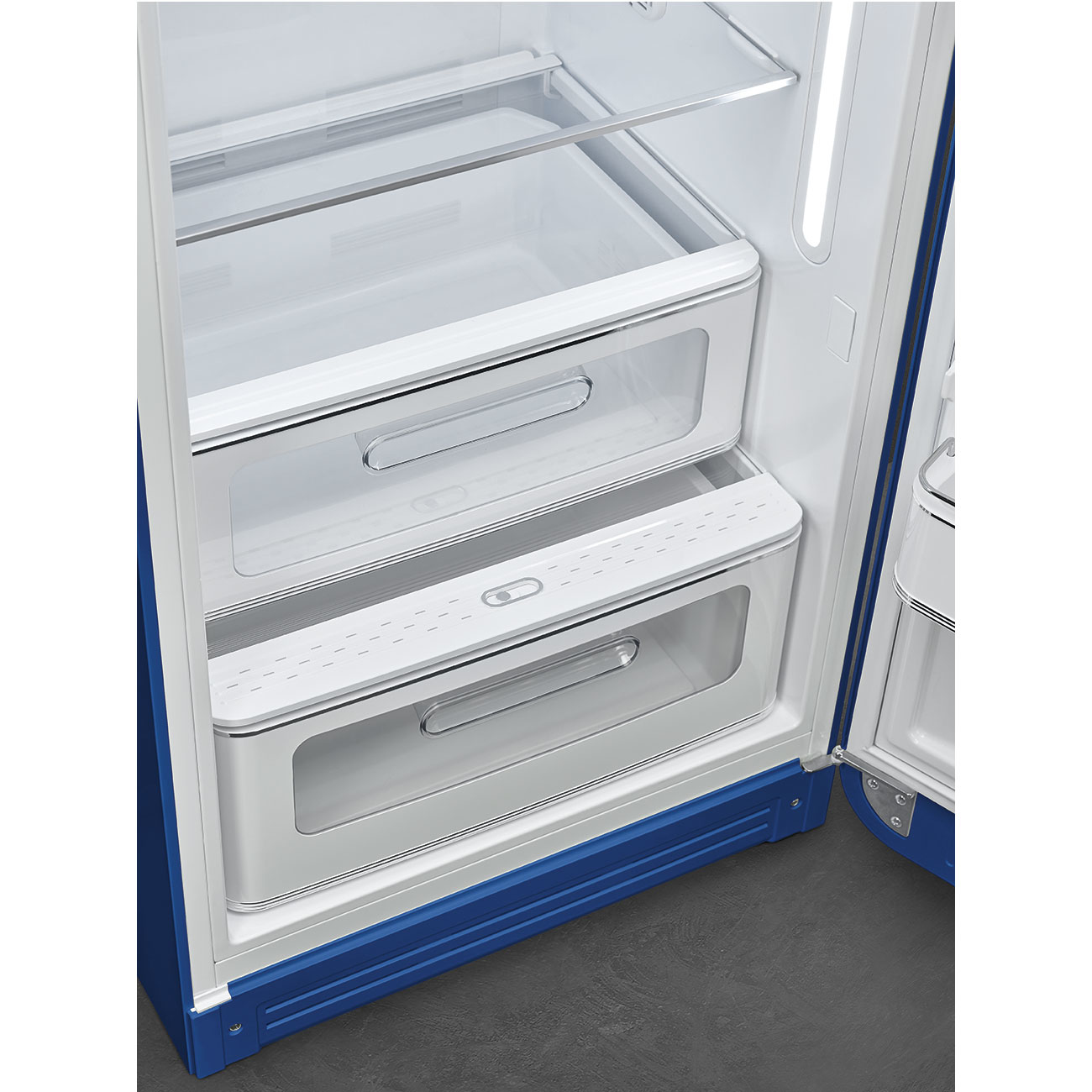 Refrigerador abierto con cajones y estantes blancos. Marco y puerta azules. Los cajones tienen asas metálicas. Interior brillante.