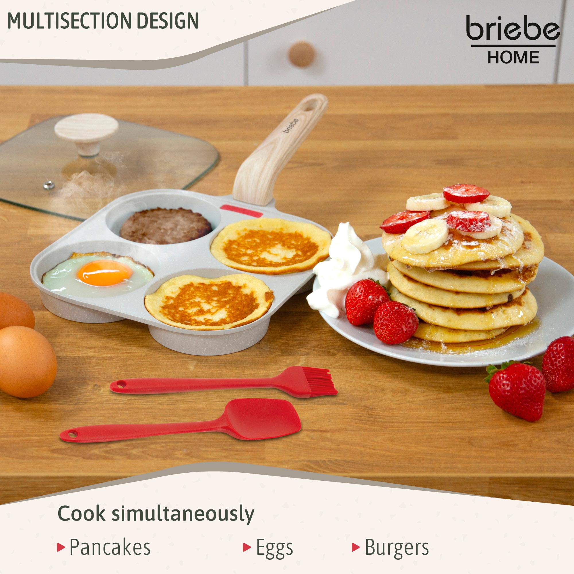Una sartén de varias secciones con panqueques, huevos y hamburguesas. Panqueques en un plato con fresas y crema batida. Utensilios rojos.
