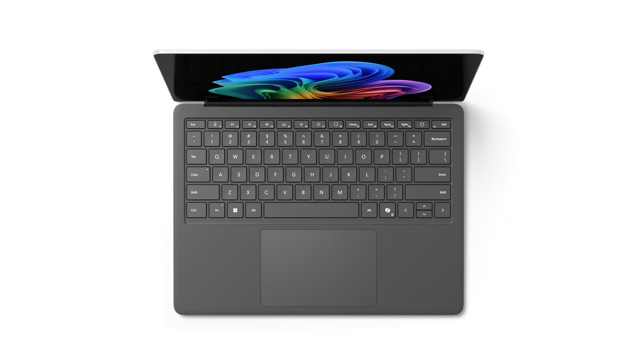 Vista aérea de un portátil gris con la tapa abierta que muestra una imagen abstracta colorida, teclado visible.