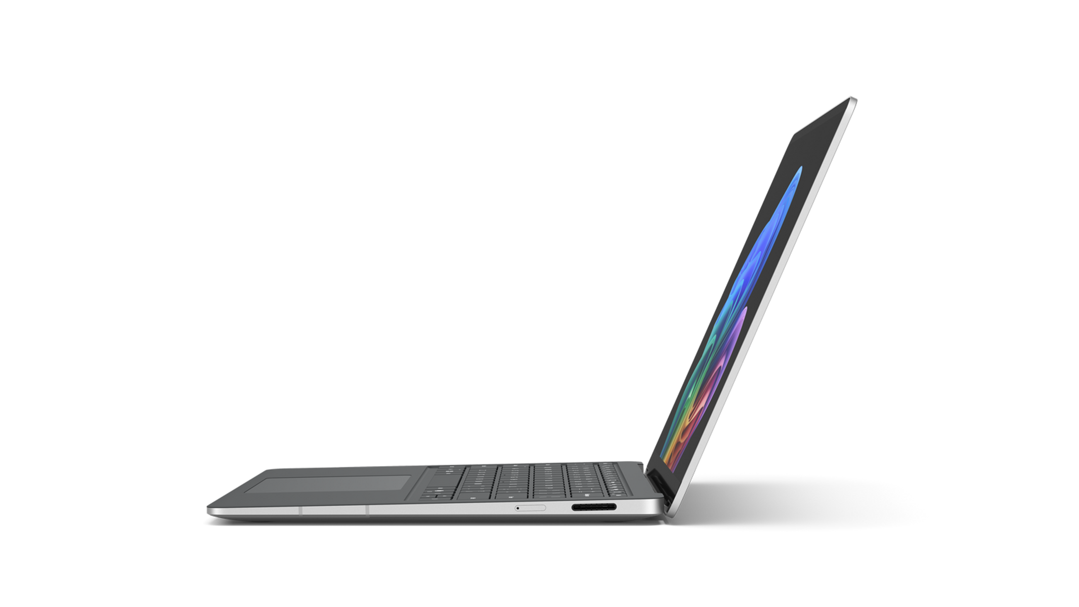 Una laptop plateada está abierta sobre un fondo negro. La pantalla muestra gráficos coloridos. El teclado es visible.