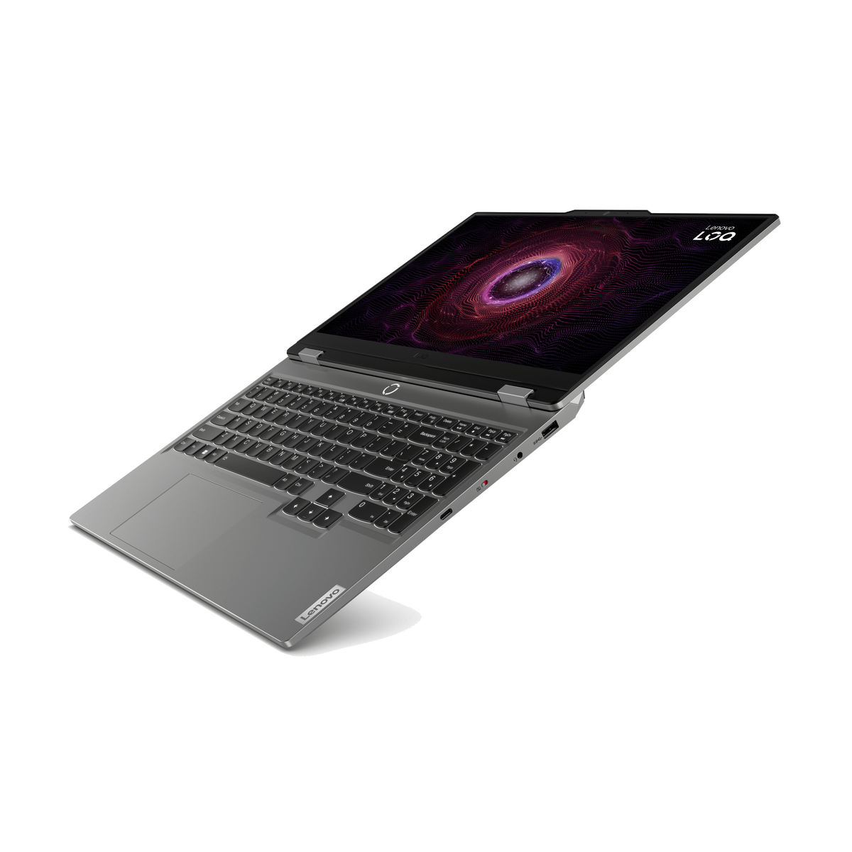 Un portátil Lenovo gris está abierto sobre una superficie negra. La pantalla muestra un diseño abstracto y colorido. El teclado es visible.