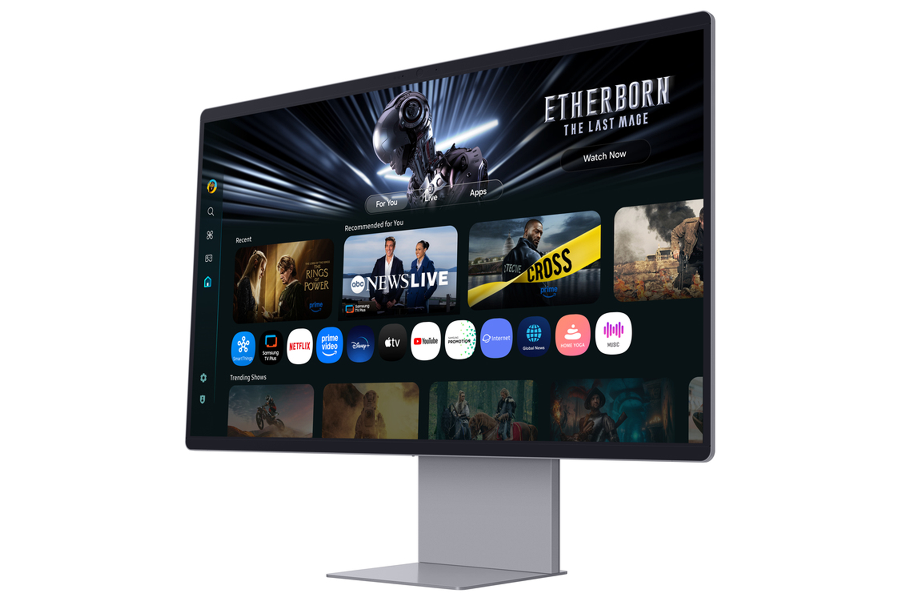 Un televisor de pantalla plana grande muestra una interfaz de servicio de transmisión. Se presentan programas como Rings of Power y Cross. El televisor está sobre un soporte plateado.
