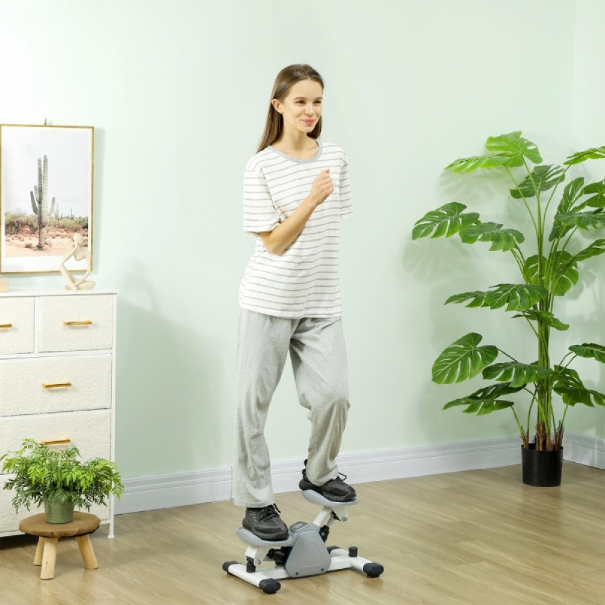 Eine Frau trainiert auf einem Stepper. Sie trägt ein gestreiftes Hemd und eine graue Hose. Im Hintergrund sind eine Pflanze und ein Schrank.