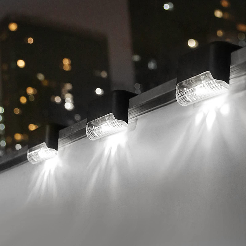 Drei LED-Leuchten sind an einer Metallstange befestigt. Die Lichter scheinen nach unten, mit verschwommenen Stadtlichtern im Hintergrund.
