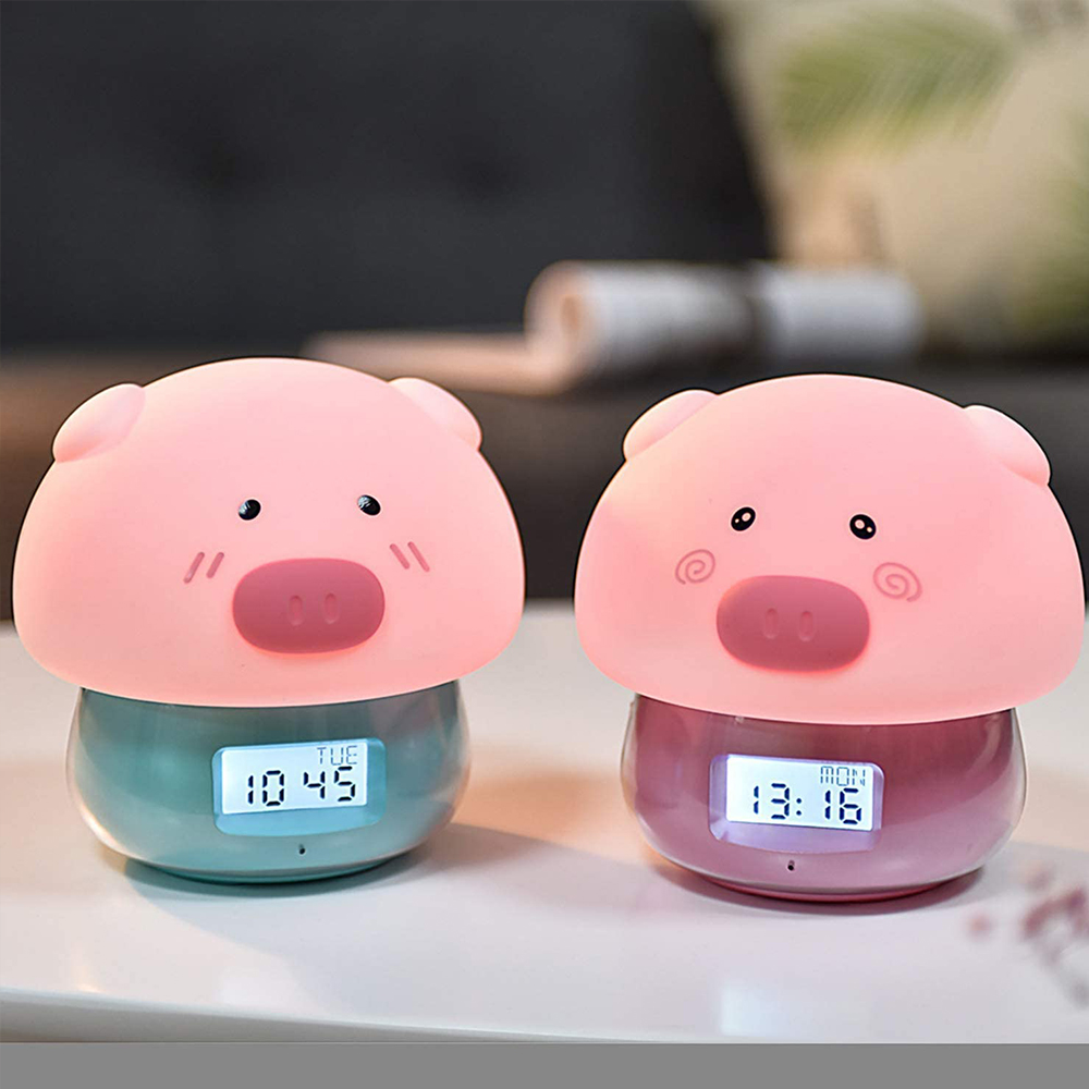 Zwei schweineförmige Wecker. Einer zeigt 10:45 Uhr am Dienstag, der andere 13:16 Uhr am Montag. Der Hintergrund ist ein verschwommenes Dunkelgrau.