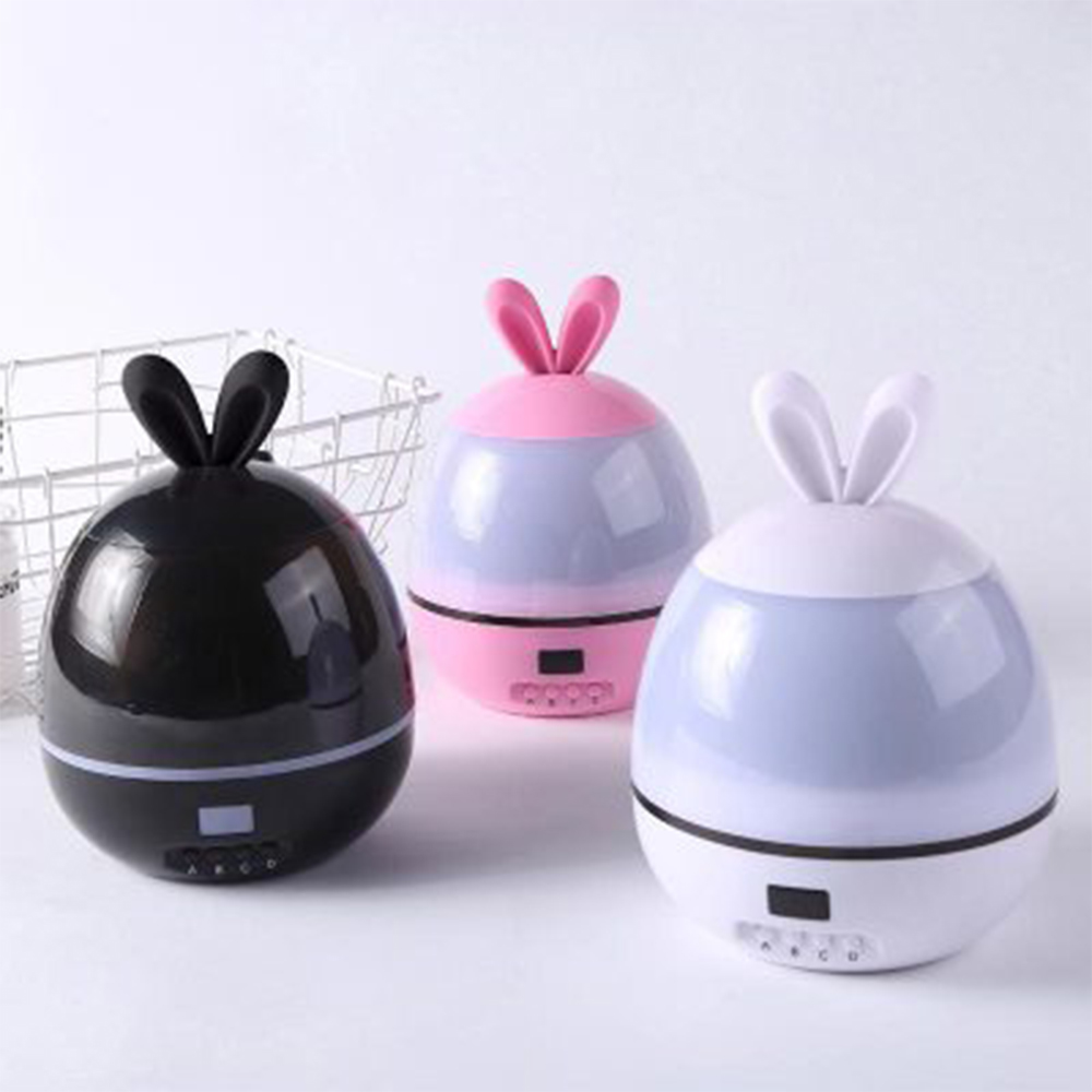 Drei eiförmige Lampen mit Hasenohren. Eine schwarz, eine rosa und eine weiß, jede mit Digitalanzeige und Knöpfen an der Basis.