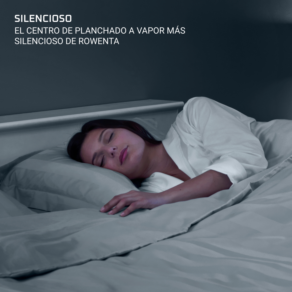 Una donna dorme pacificamente a letto, coperta da una coperta grigia. La stanza è scarsamente illuminata. Il testo in alto dice 'SILENCIOSO'.