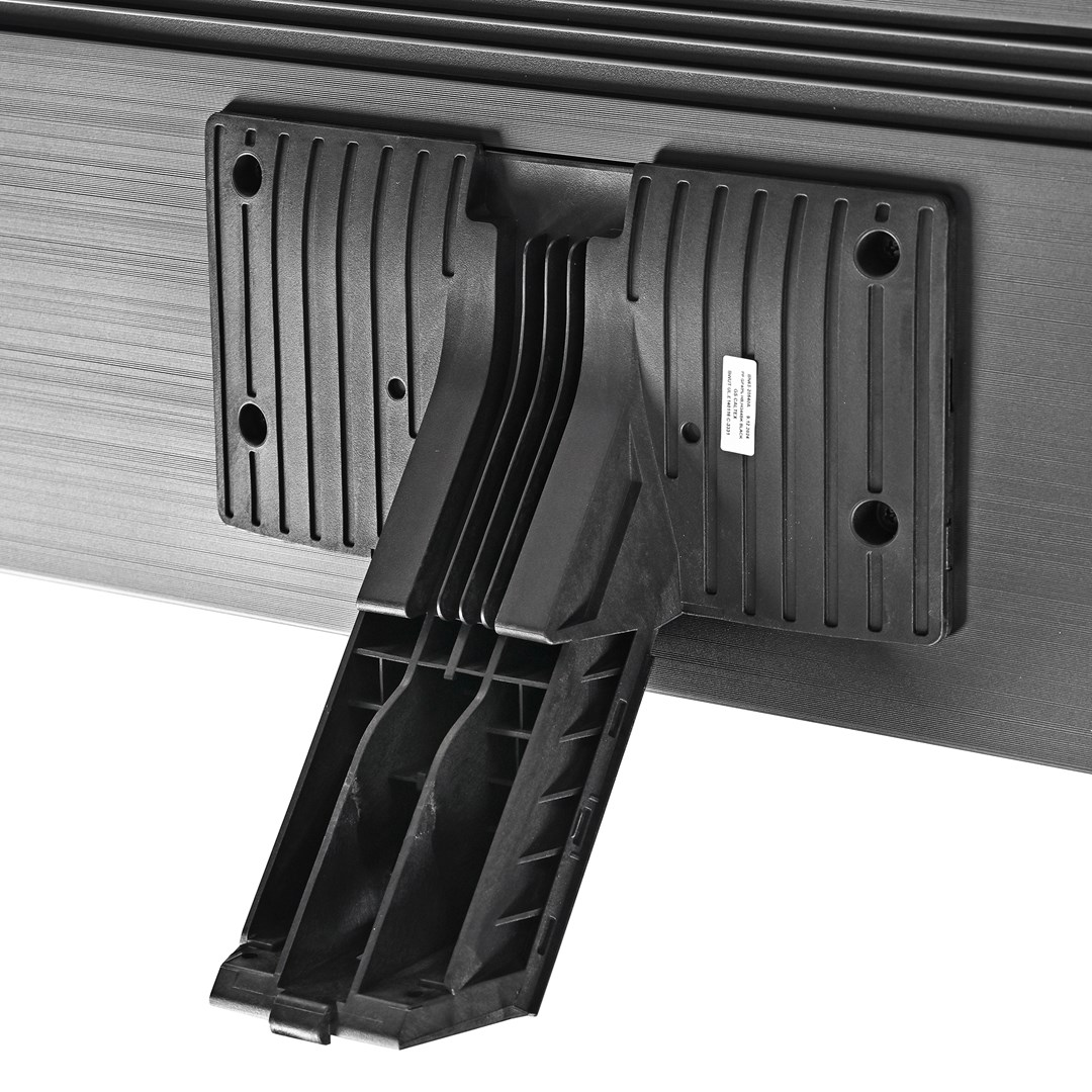 Zbliżenie czarnego plastikowego stojaka przymocowanego do ciemnoszarej, poziomo żłobionej powierzchni. Stojak jest częściowo otwarty.