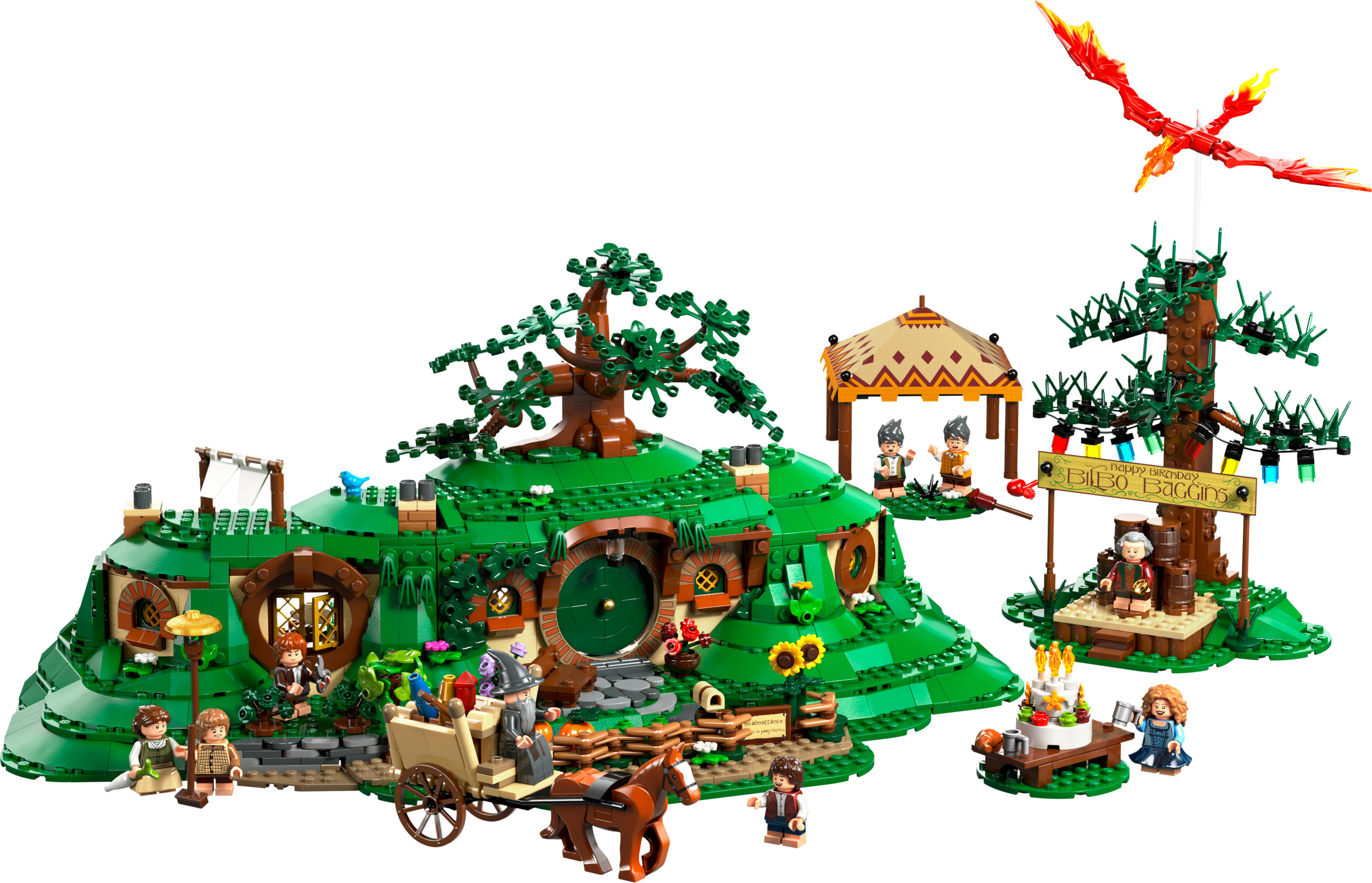 Zestaw Lego domu Hobbita z figurkami, drzewem, znakiem i modelem feniksa. Figurki rozmieszczone wokół domu Hobbita.