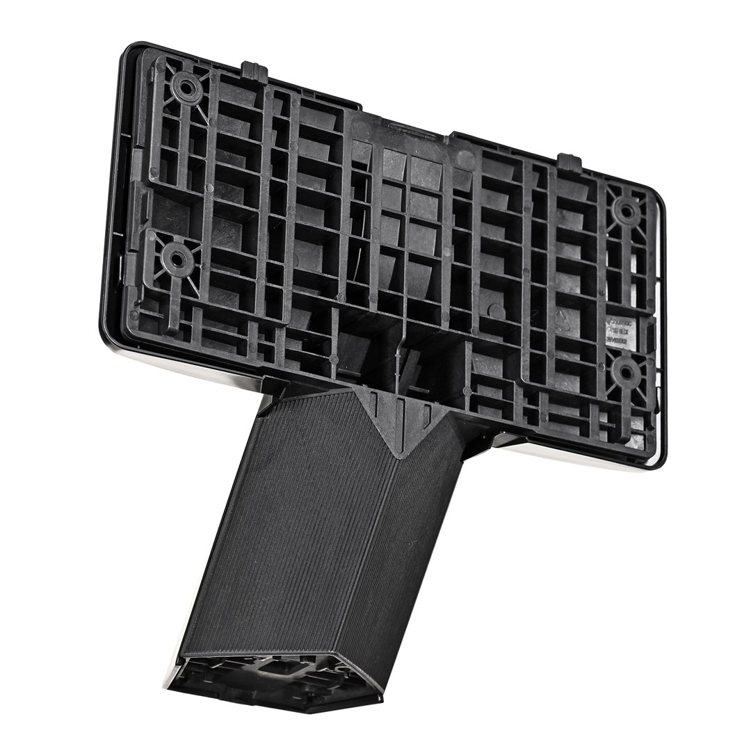 Czarny element z tworzywa sztucznego, z prostokątną górą z wzorem kratki i kątową, żebrowaną sekcją rozciągającą się w dół.