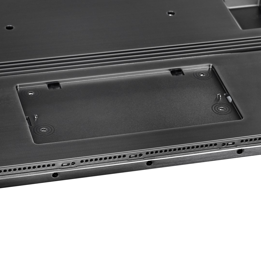 Zbliżenie ciemnego metalowego elementu z prostokątnym zagłębieniem i małymi otworami wzdłuż krawędzi, na białym tle.