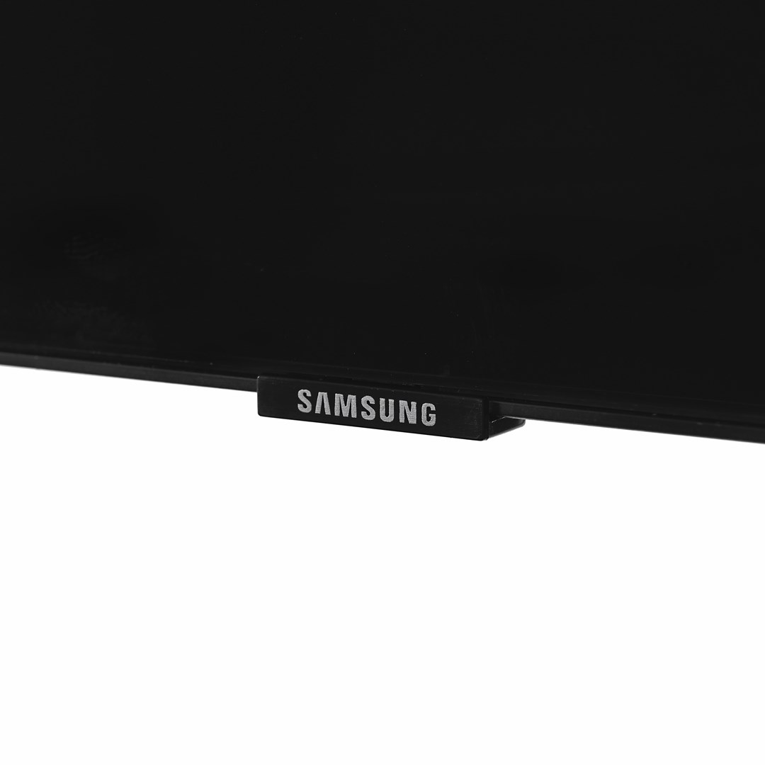 Een close-up van een zwarte Samsung TV. Het logo is zichtbaar op een klein, rechthoekig stukje aan de onderkant.