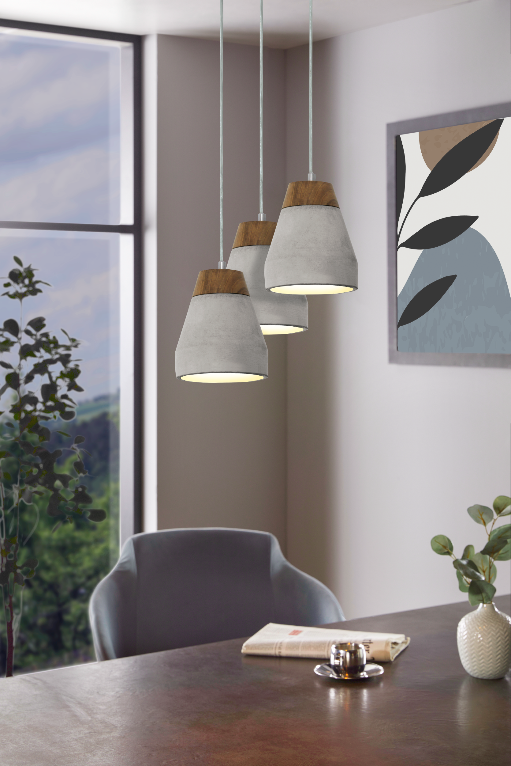 Drei Pendelleuchten mit Holzaufsätzen hängen über einem dunklen Tisch. Ein Fenster und Kunstwerke sind sichtbar.