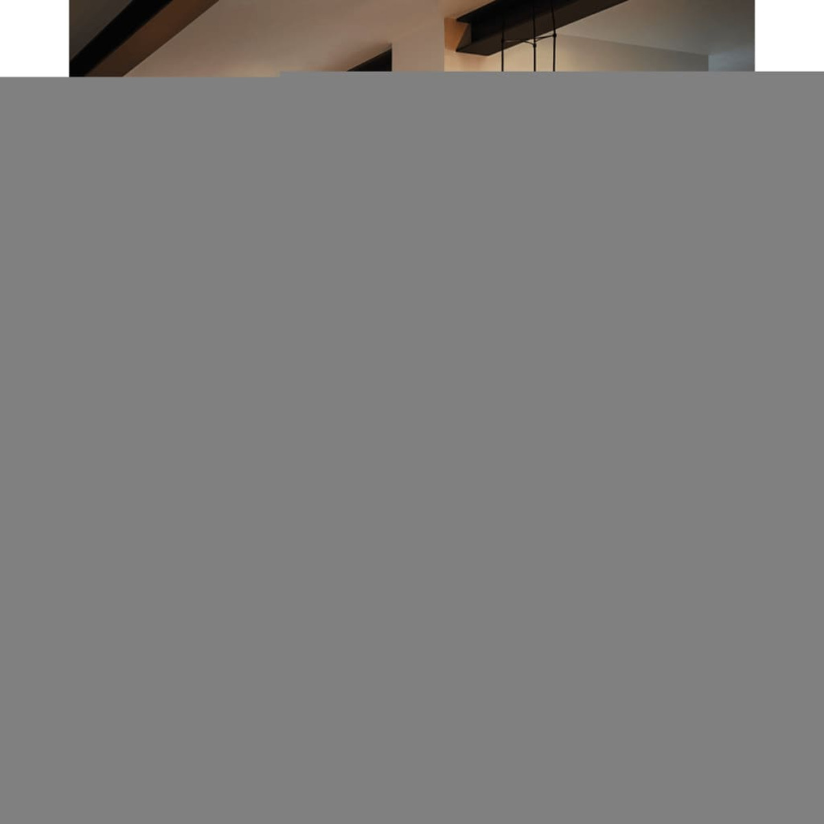 Un soffitto moderno con travi nere e un lampadario. Lo sfondo è un muro di colore chiaro.