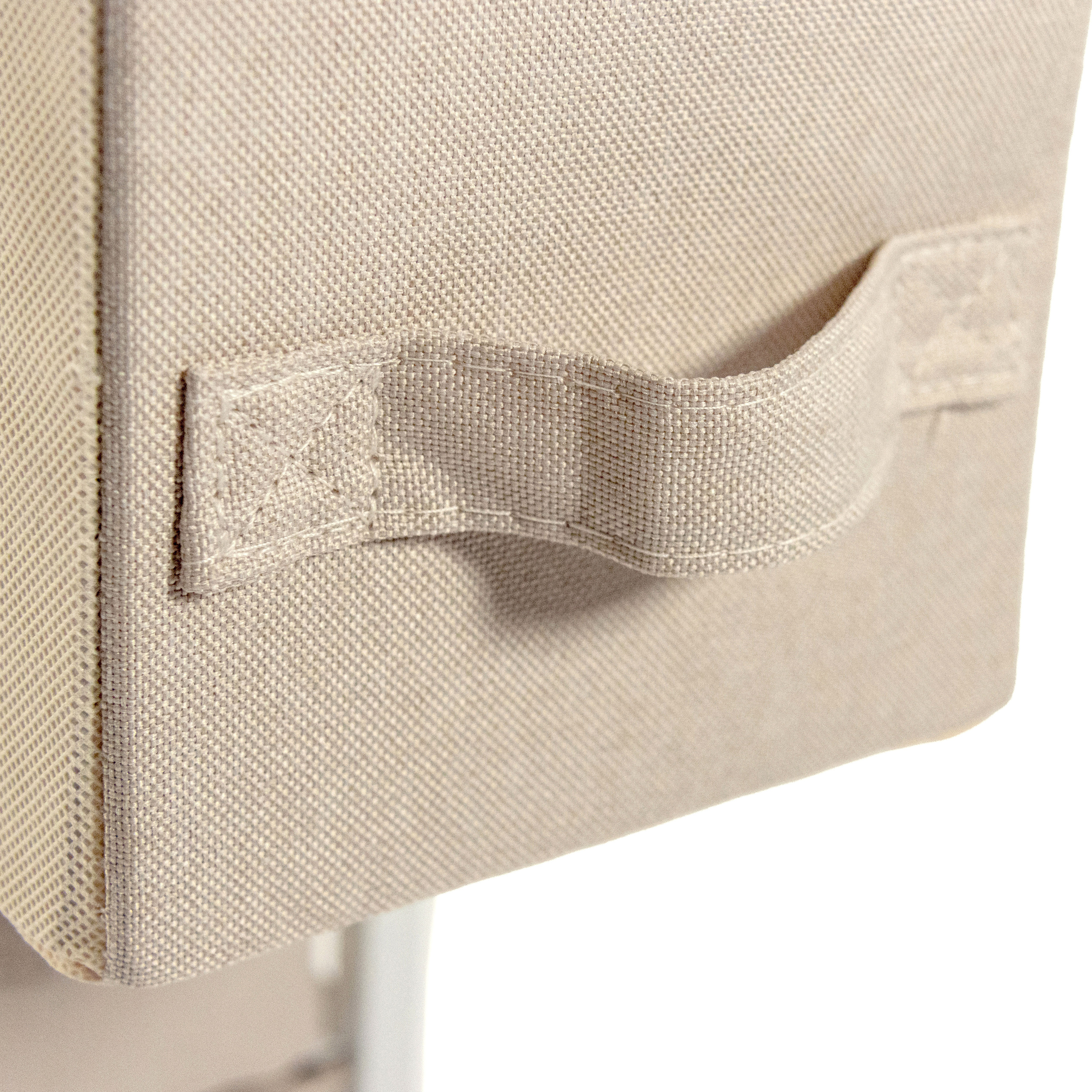 Nahaufnahme einer beige Stoff-Aufbewahrungsbox mit Griff. Die Box ist strukturiert. Weißer Hintergrund.