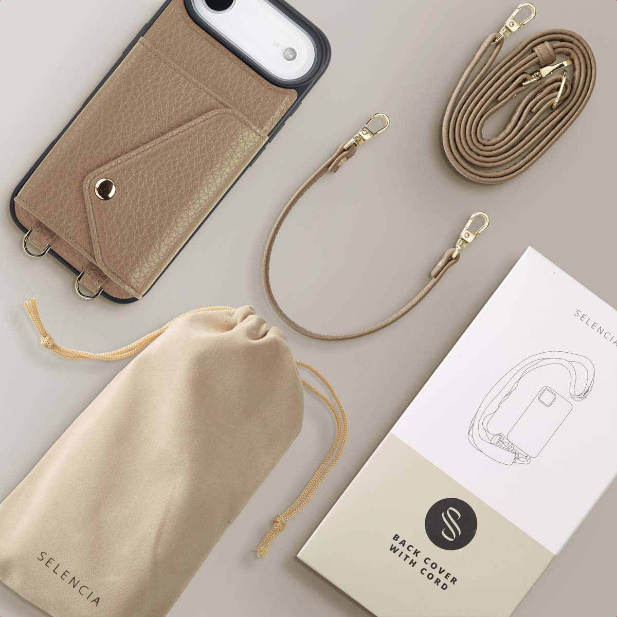 Een beige telefoonhoesje met een riem, een zakje met trekkoord en een doos met het label 'Back Cover With Cord' zijn gerangschikt.