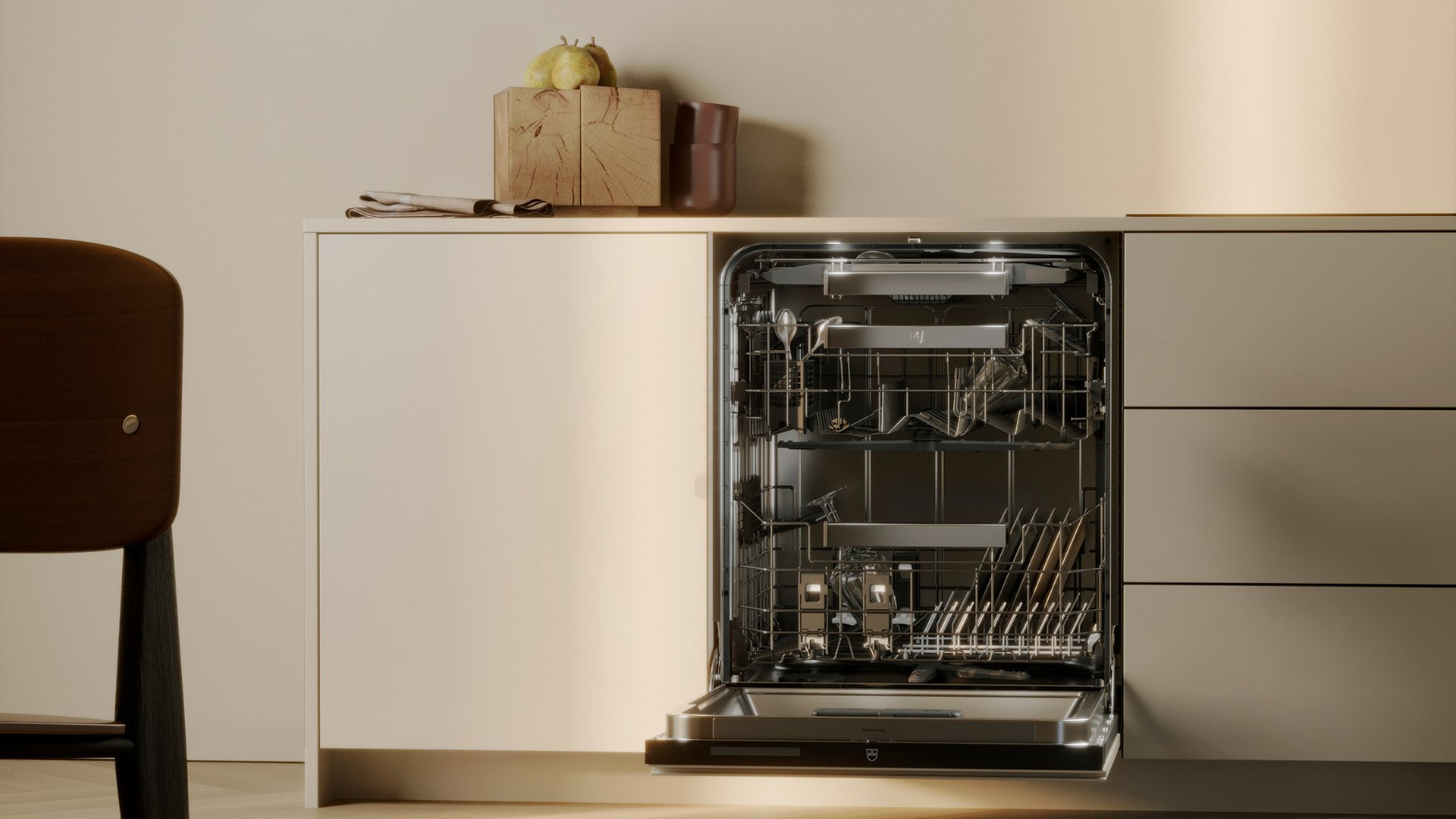 Lavastoviglie aperta con utensili all'interno. Blocco di legno e tazza marrone sul bancone. Sedia di legno a sinistra.