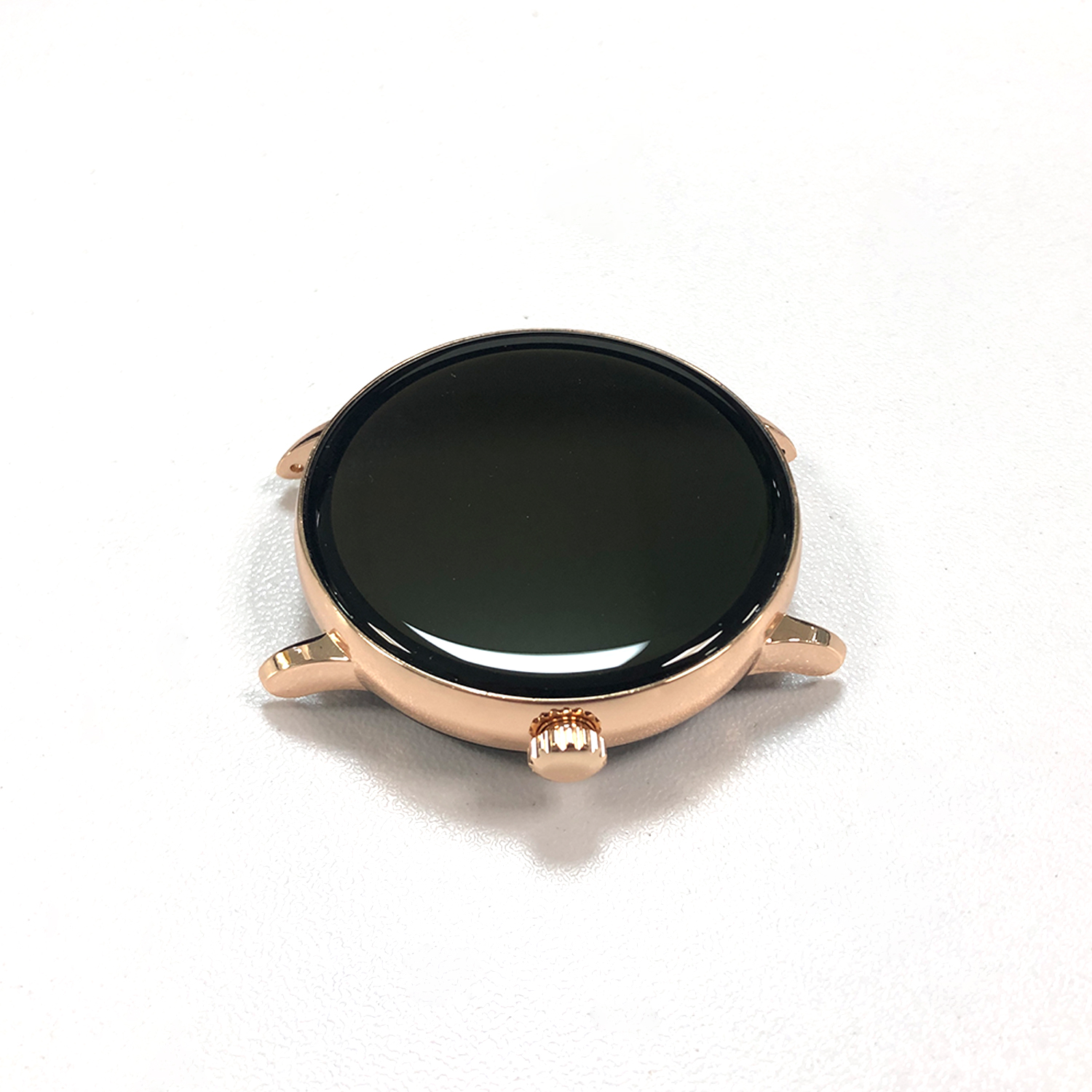 Tarcza smartwatcha w kolorze różowego złota na białej powierzchni. Ma czarny ekran i małe uchwyty na pasek.