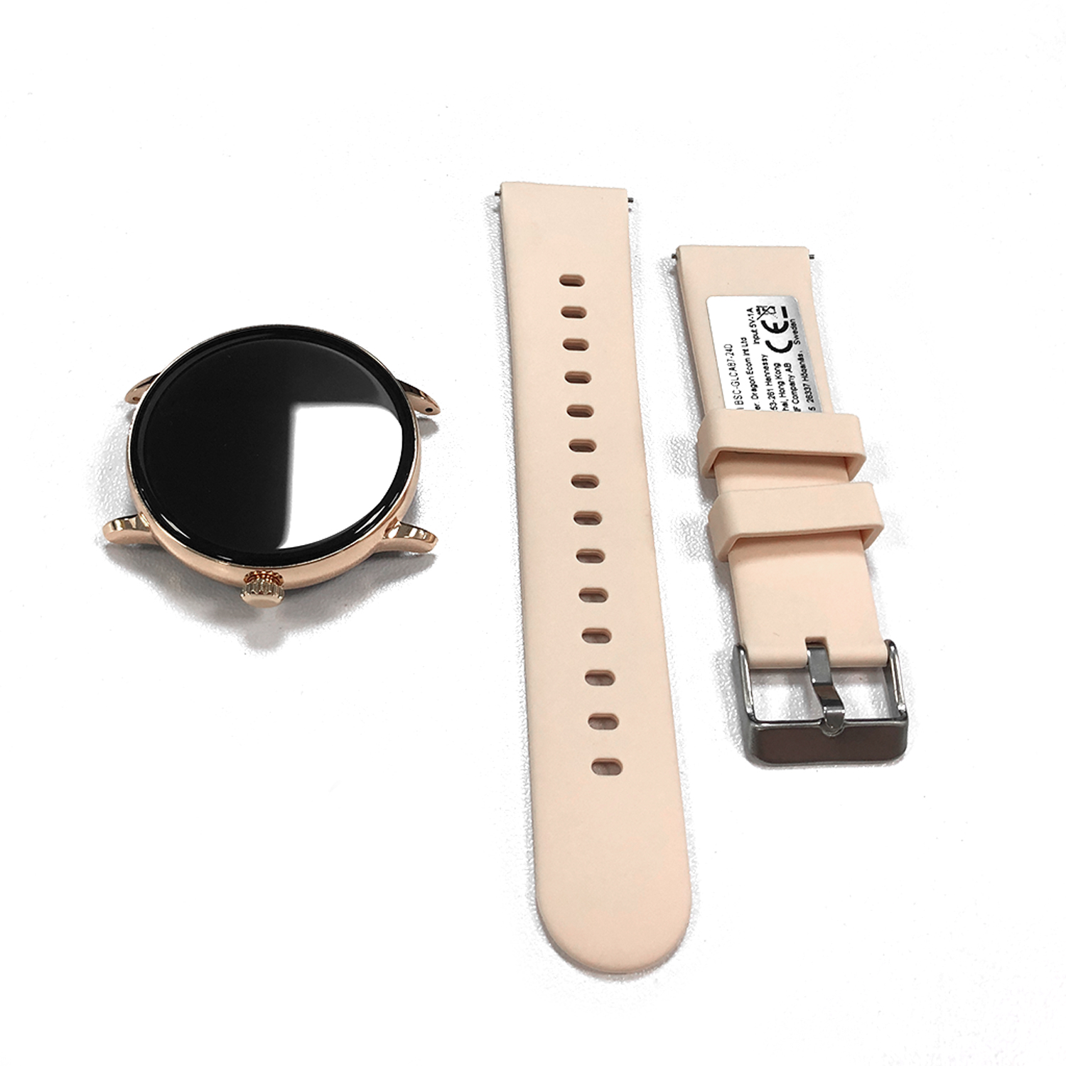 Zdemontowany smartwatch z okrągłą obudową w kolorze różowego złota, czarnym ekranem i jasnoróżowymi paskami na białej powierzchni.