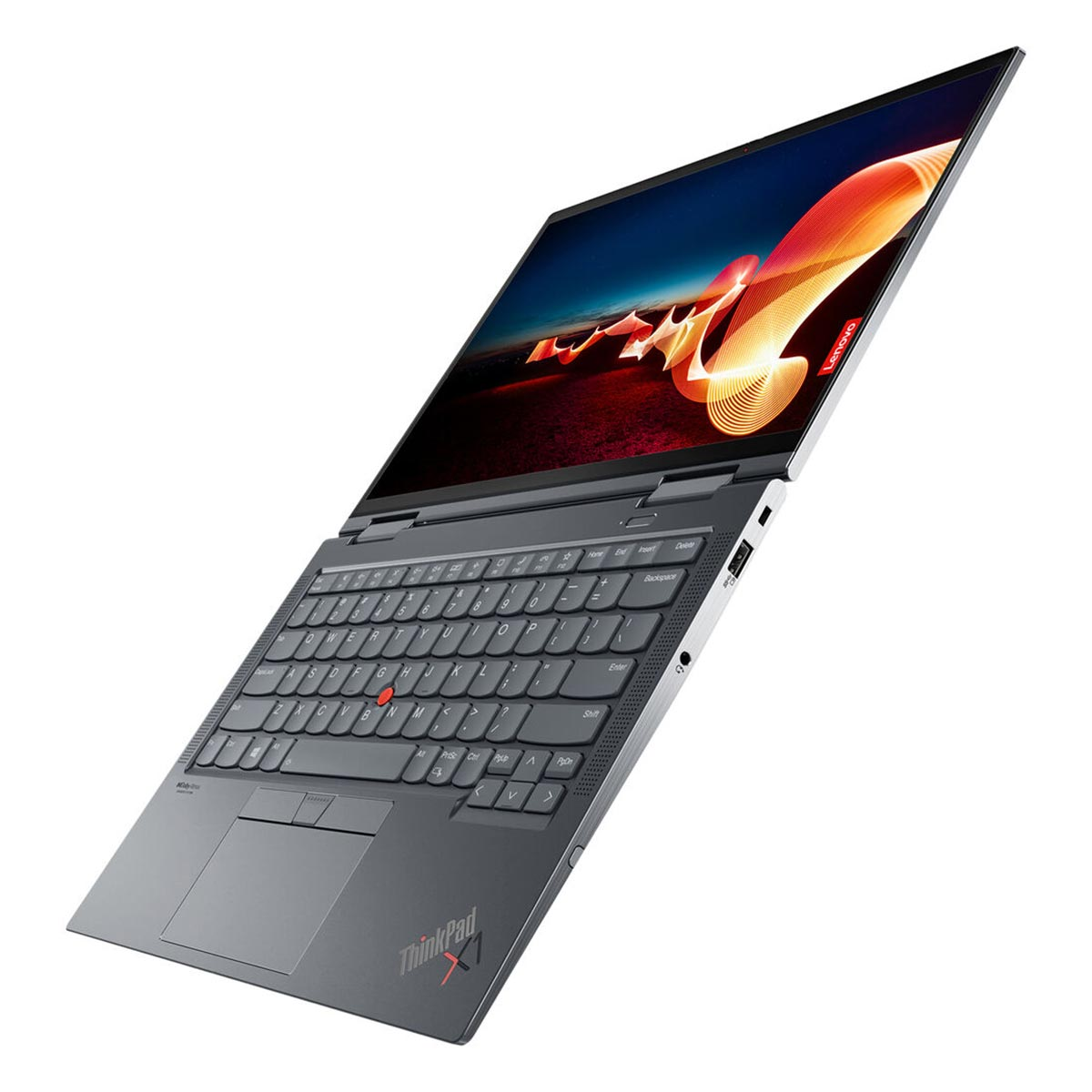 Szary laptop ThinkPad X1 jest otwarty, ustawiony pod kątem na białej powierzchni. Ekran pokazuje kolorowy, abstrakcyjny obraz.