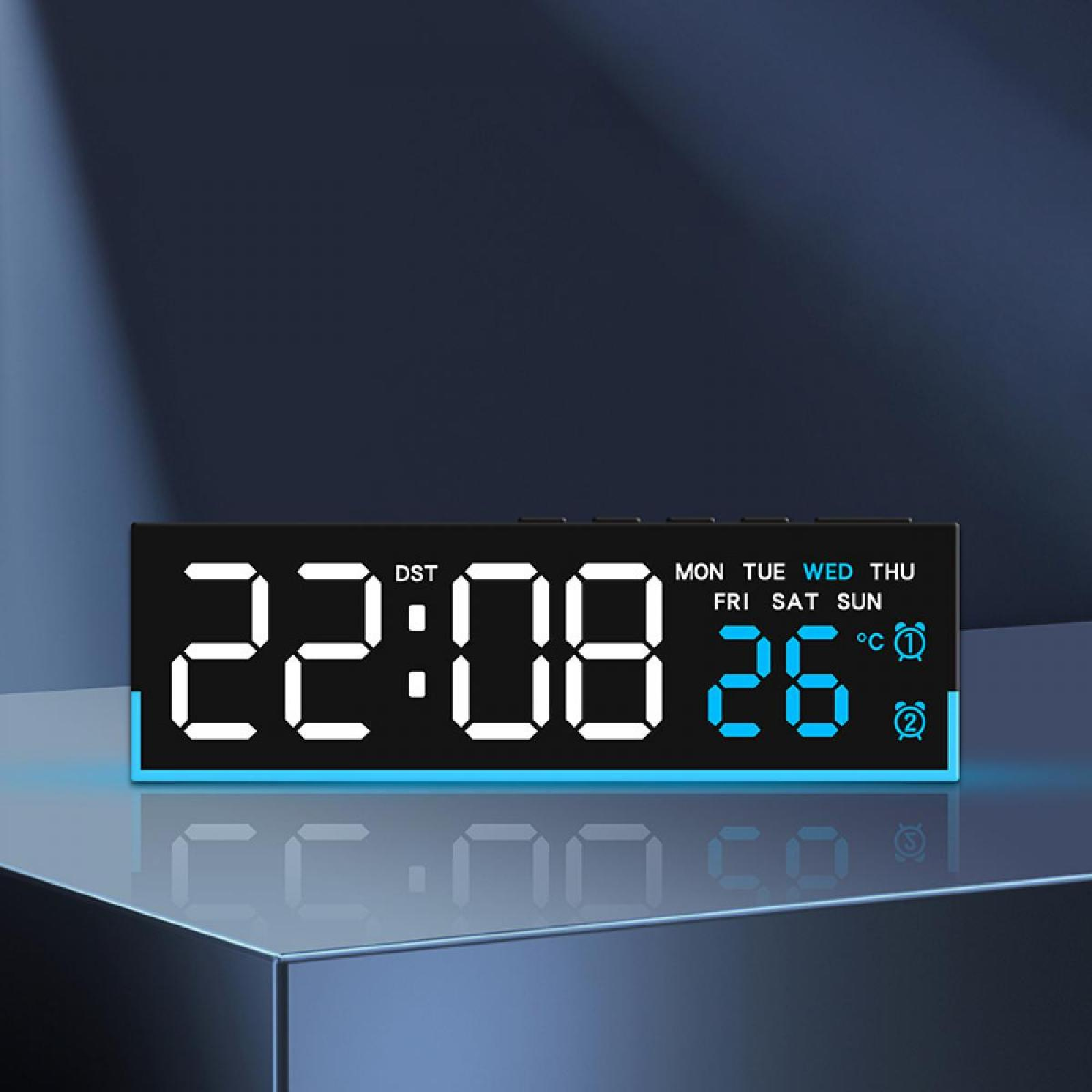 Eine Digitaluhr zeigt 22:08 und 26 an. Die Uhr ist schwarz mit weißen Ziffern und einem blauen Rand. Der Hintergrund ist dunkel.