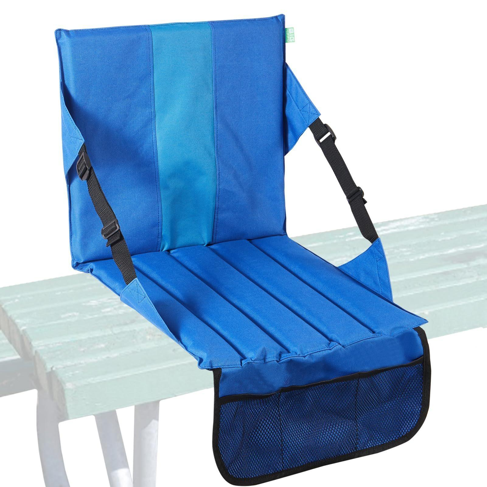 Ein blauer Stadionsitz mit Rückenlehne, Gurten und einer Netztasche befindet sich auf einer Bank.