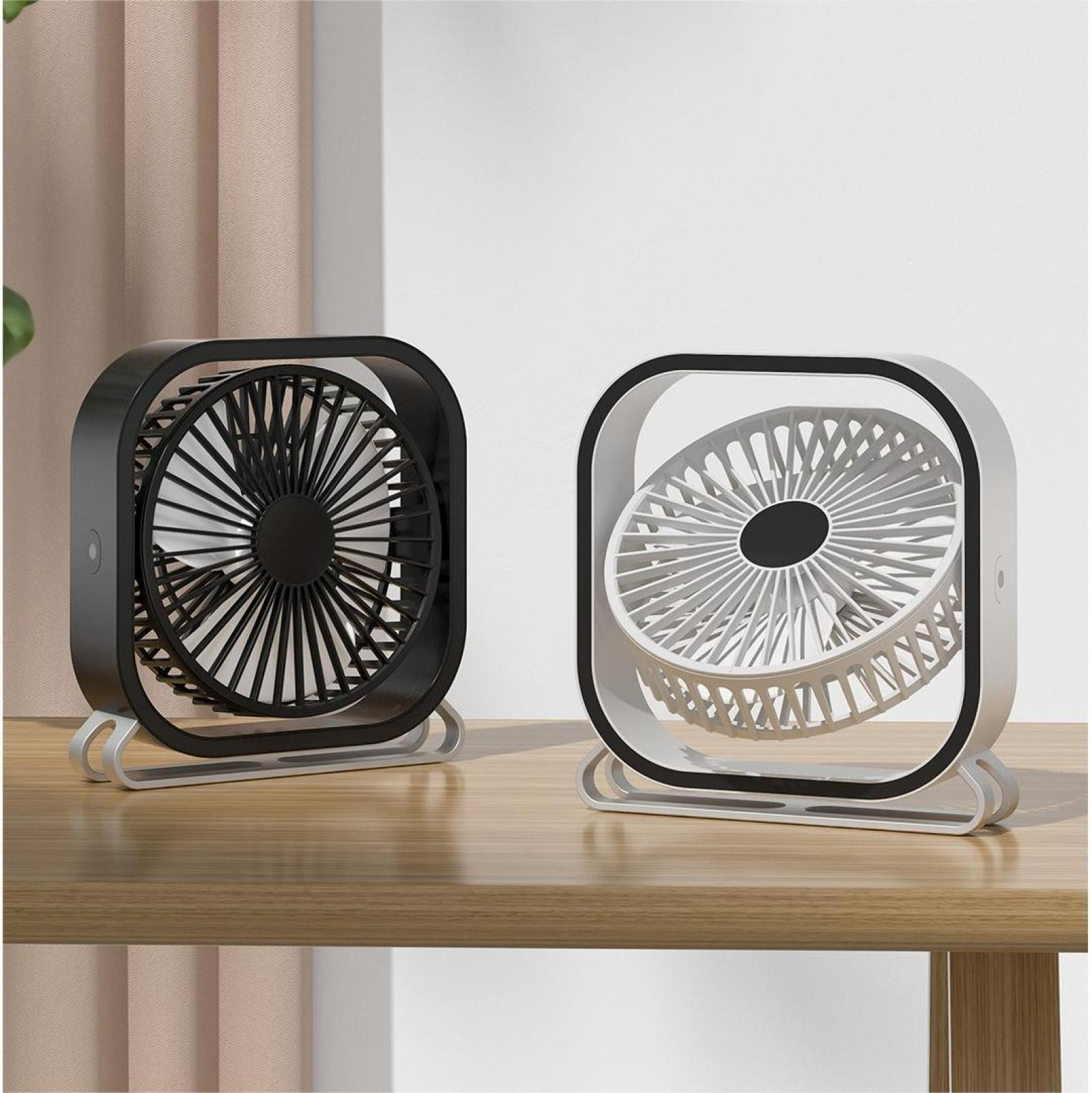 Zwei kleine Ventilatoren, einer schwarz und einer weiß, stehen auf einer Holzoberfläche. Der schwarze Ventilator ist links, der weiße rechts.