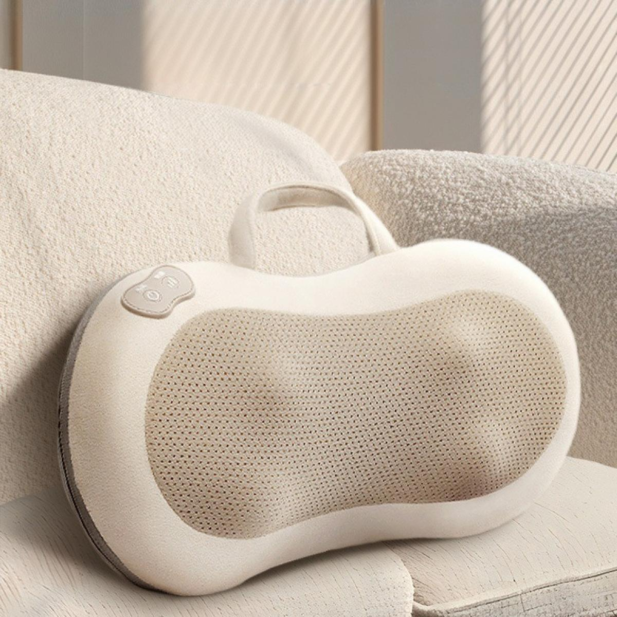Ein weißes und beiges Massagekissen mit Griff und Bedienelementen liegt auf einem Stuhl. Der Hintergrund zeigt ein Sofa.