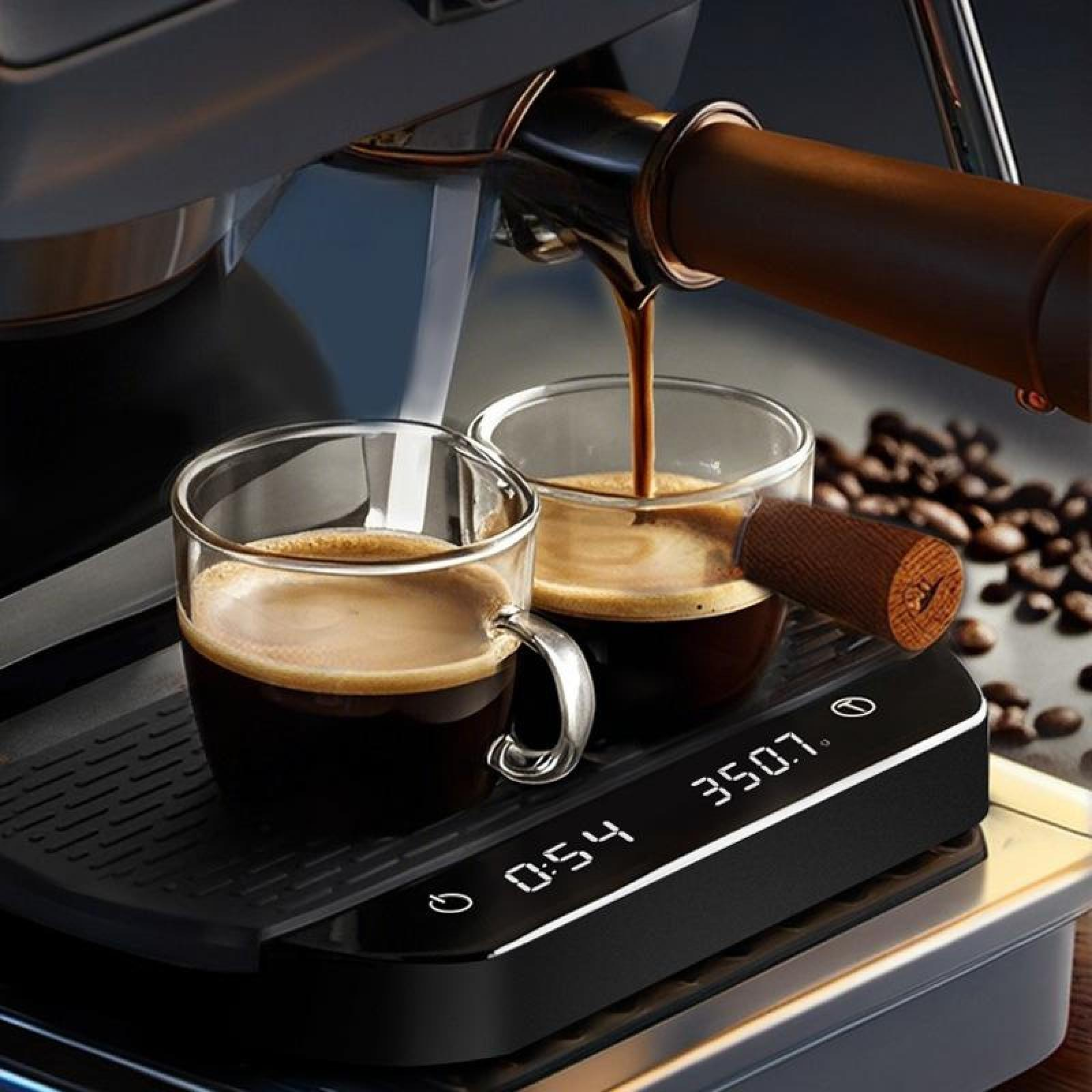 Espressomaschine gießt Kaffee in zwei Gläser auf einer Waage. Kaffeebohnen im Hintergrund.