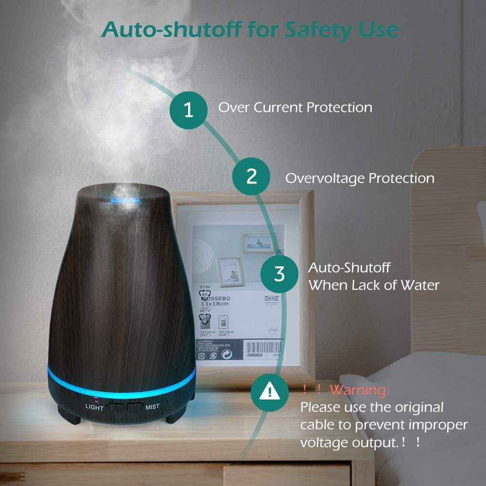 Ein Aromatherapie-Diffusor steht auf einem Nachttisch. Er hat eine Holzmaserung, blaues Licht und Dampf. Ein Rahmen und ein Warnhinweis sind sichtbar.