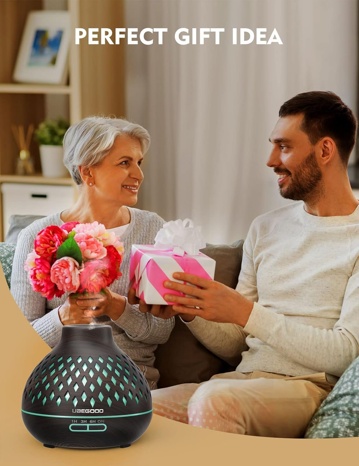 Ein Mann gibt einer Frau ein Geschenk, die Blumen hält. Im Vordergrund befindet sich ein Diffusor für ätherische Öle. Die Szene deutet auf Schenken hin.