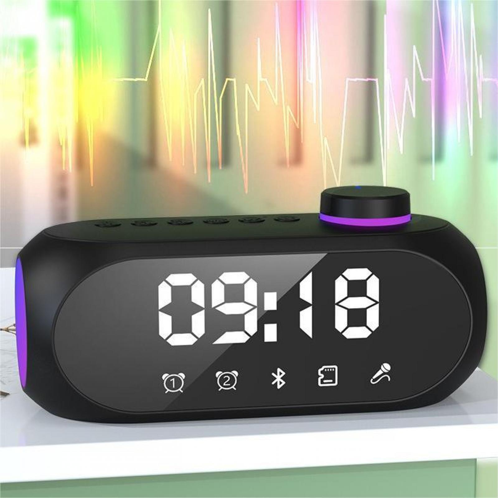 Schwarze Digitaluhr zeigt 09:18. Sie hat einen Drehregler und einen Lautsprecher. Buntes Licht im Hintergrund.