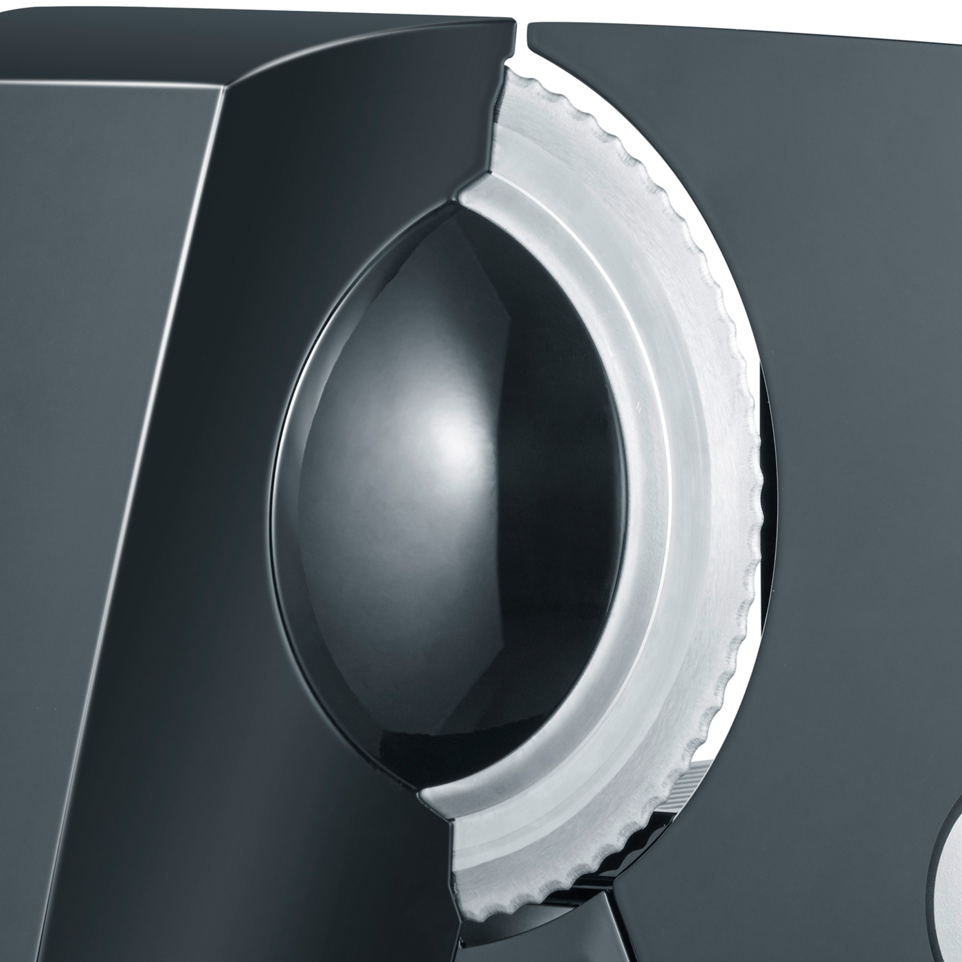 Primo piano di un affettatrice nera. È visibile una lama circolare e affilata. Il design è elegante e moderno.
