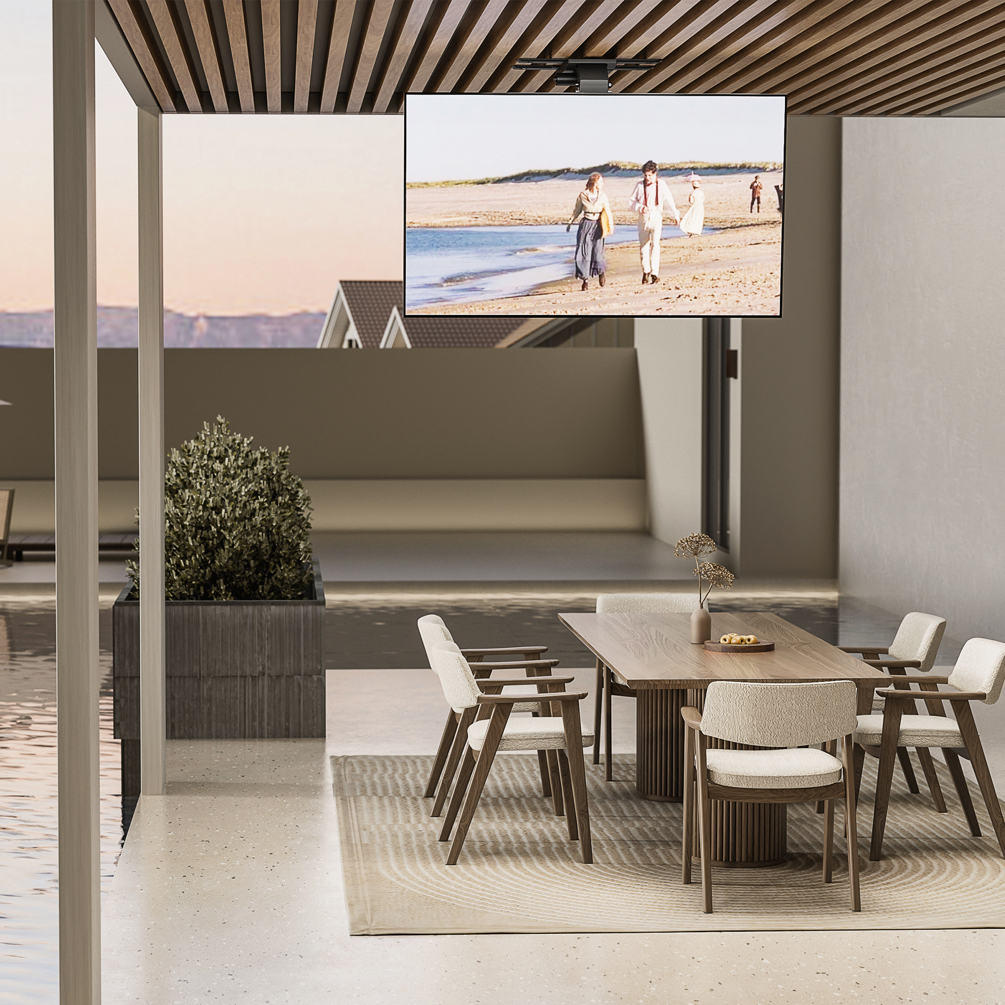 Essbereich im Freien mit einem Fernseher, der Menschen am Strand zeigt. Enthält einen Tisch, Stühle und eine Pflanze.