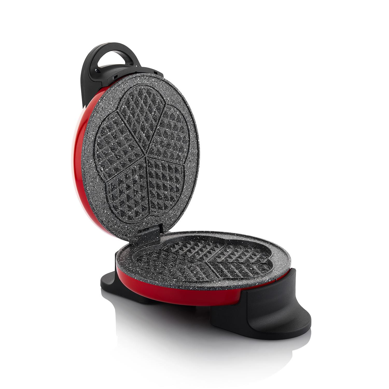Kırmızı ve siyah waffle makinesi açık. Üst yarısı çiçek şeklinde. Alt kısım açık. Beyaz bir arka plan üzerinde izole edilmiştir.