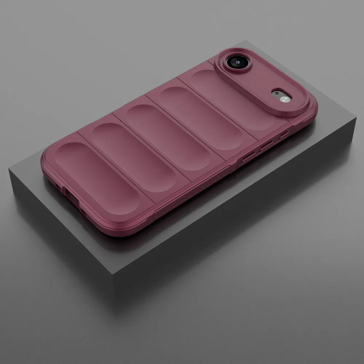 Een bordeauxrode telefoonhoes met een verhoogd cameragedeelte en vier verticale ribbels op een donkergrijs platform.