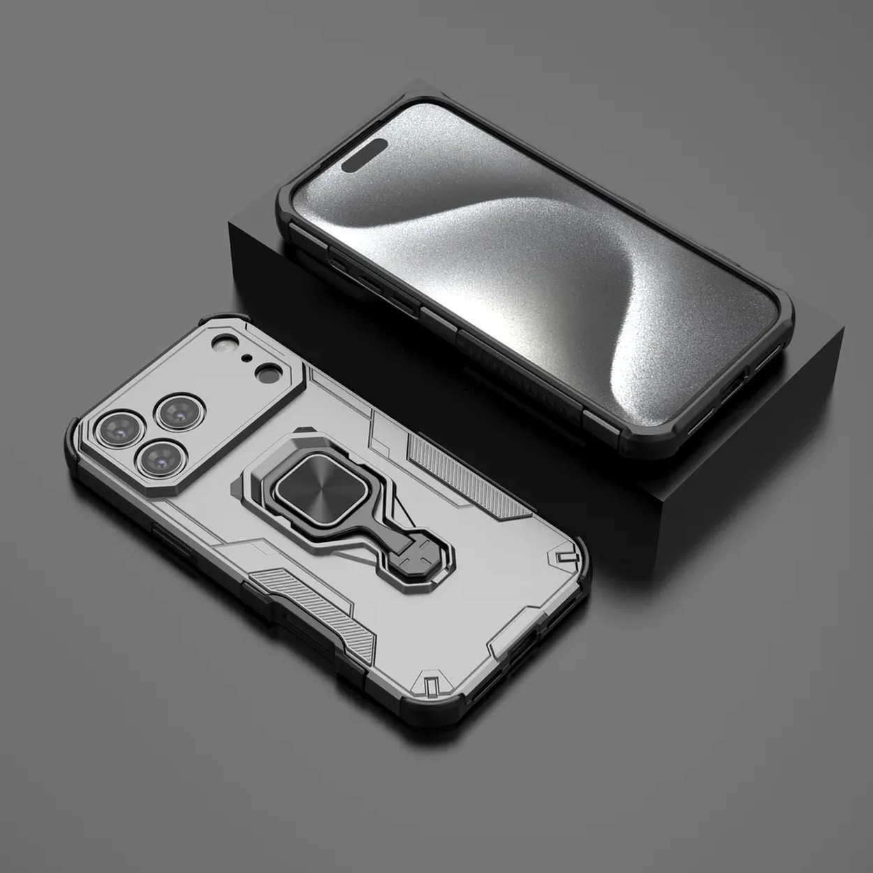 Twee telefoonhoesjes op een donker oppervlak. Eén is zilver met een ringhouder, de andere is zwart, met het scherm naar boven.
