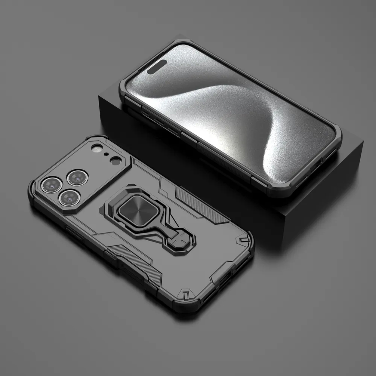 Deux étuis de téléphone noirs. L'un a un support d'anneau, l'autre est sur un bloc noir. Les deux sont sur une surface grise.