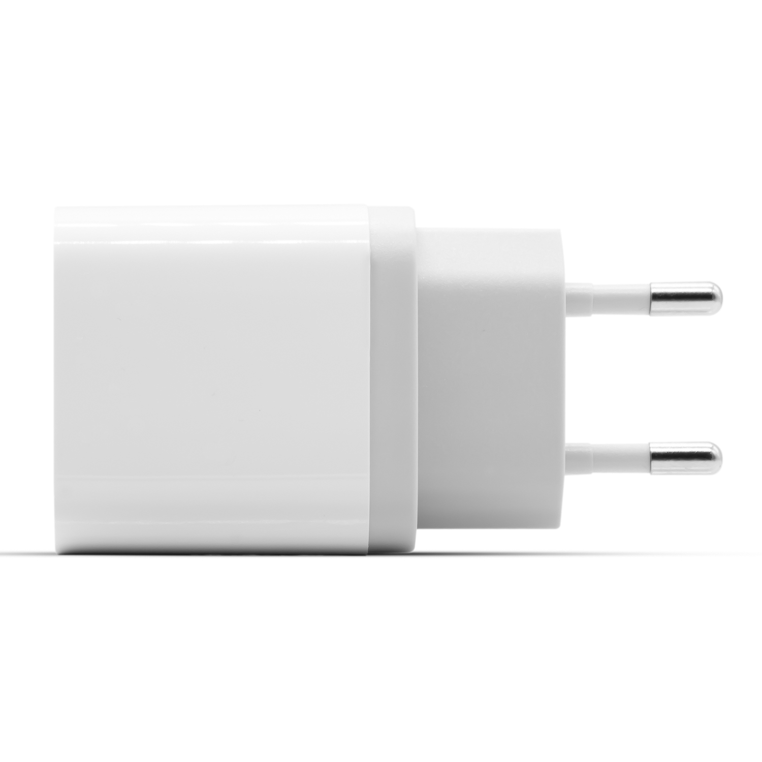 Un chargeur de téléphone blanc avec deux broches argentées sur fond blanc. Le chargeur est rectangulaire.