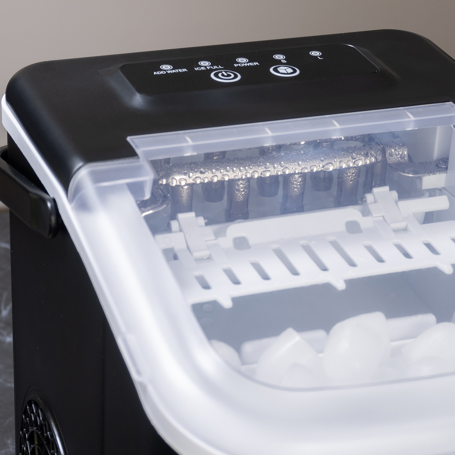A black and white ice maker is shown. It has a clear lid and a tray with ice cubes. The top has control buttons.