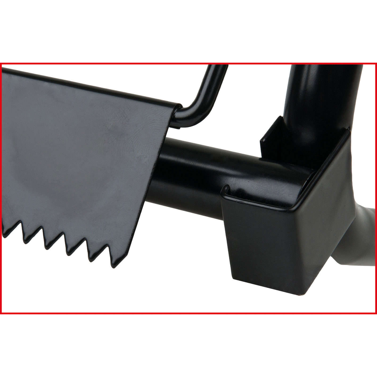 Primo piano di uno strumento in metallo nero con bordo seghettato e manico curvo, isolato su sfondo bianco.