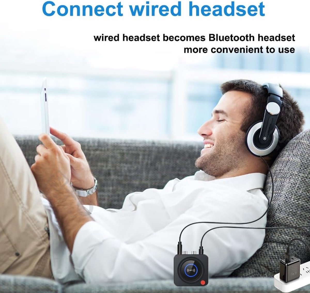 Man wearing headphones and looking at a tablet. A black device connects to the headphones via cable. Text: Connect wired headset.