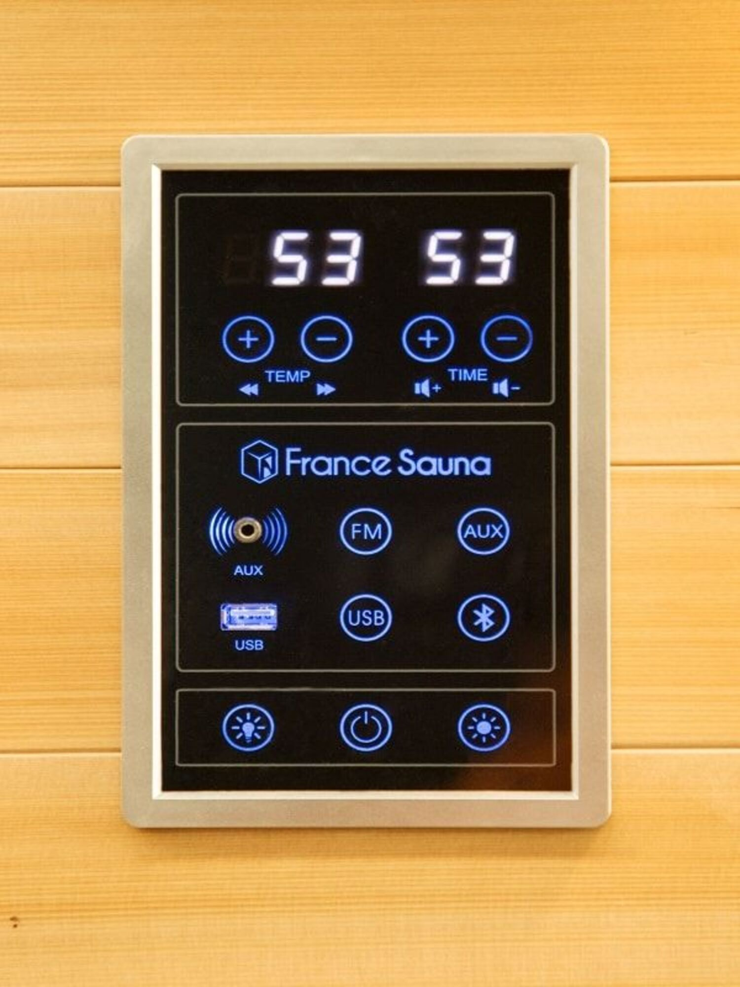 Un panel de control de sauna muestra 53 y 53, con controles de temperatura y tiempo. Incluye AUX, USB, FM y Bluetooth.