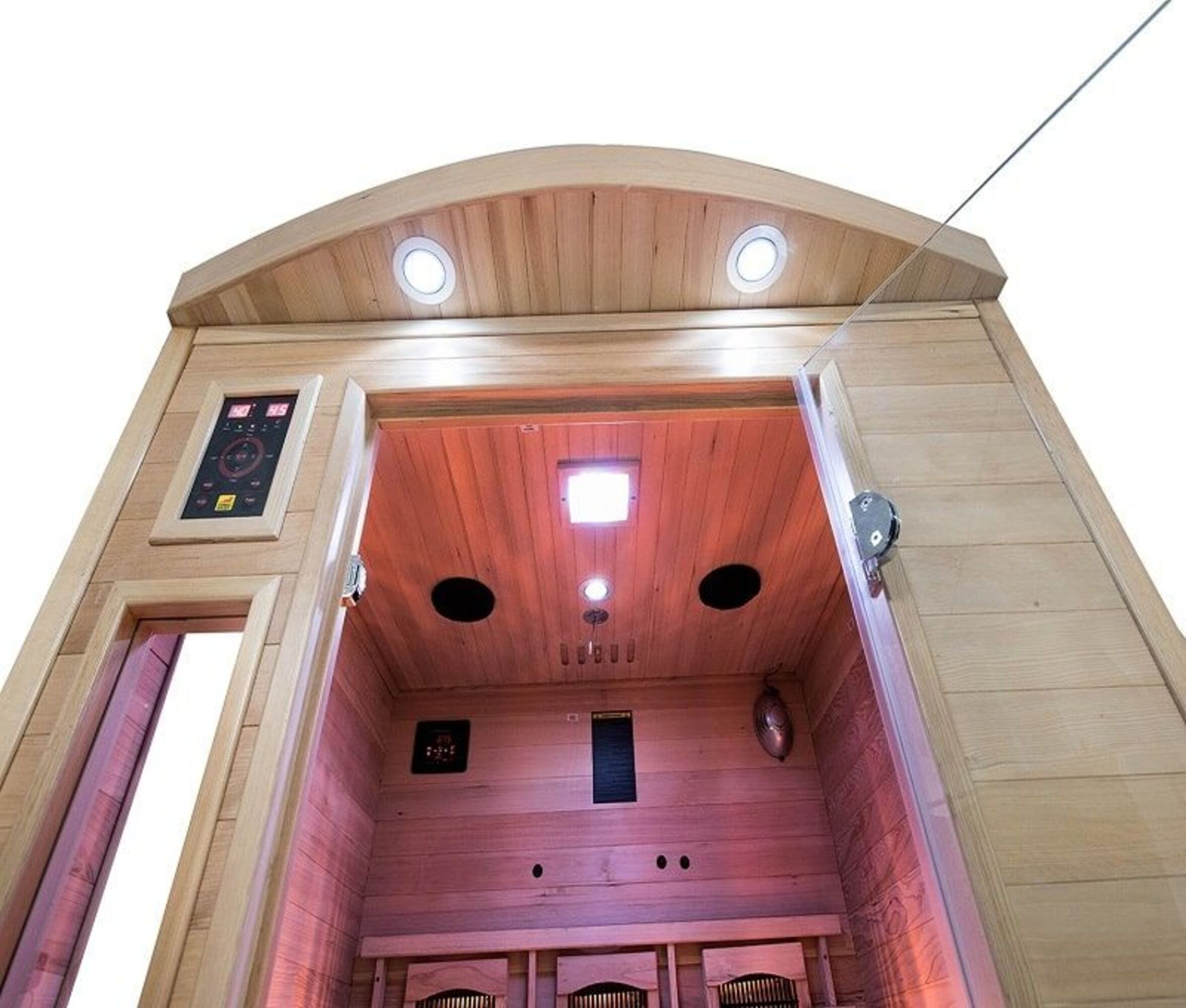 Interior de sauna de madera con luces, panel de control y puerta de cristal. Adentro, bancos y ventilación.